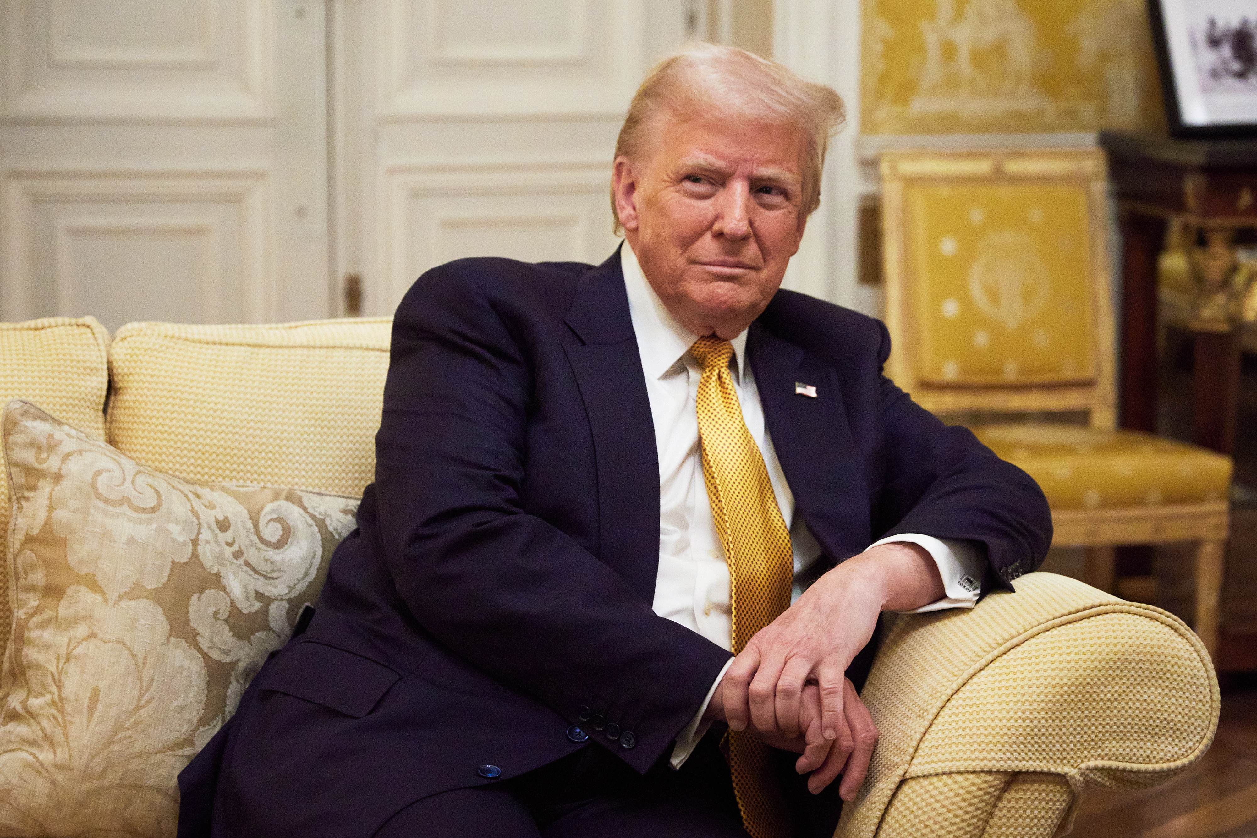 Donald Trump sits in the White House on a couch. 