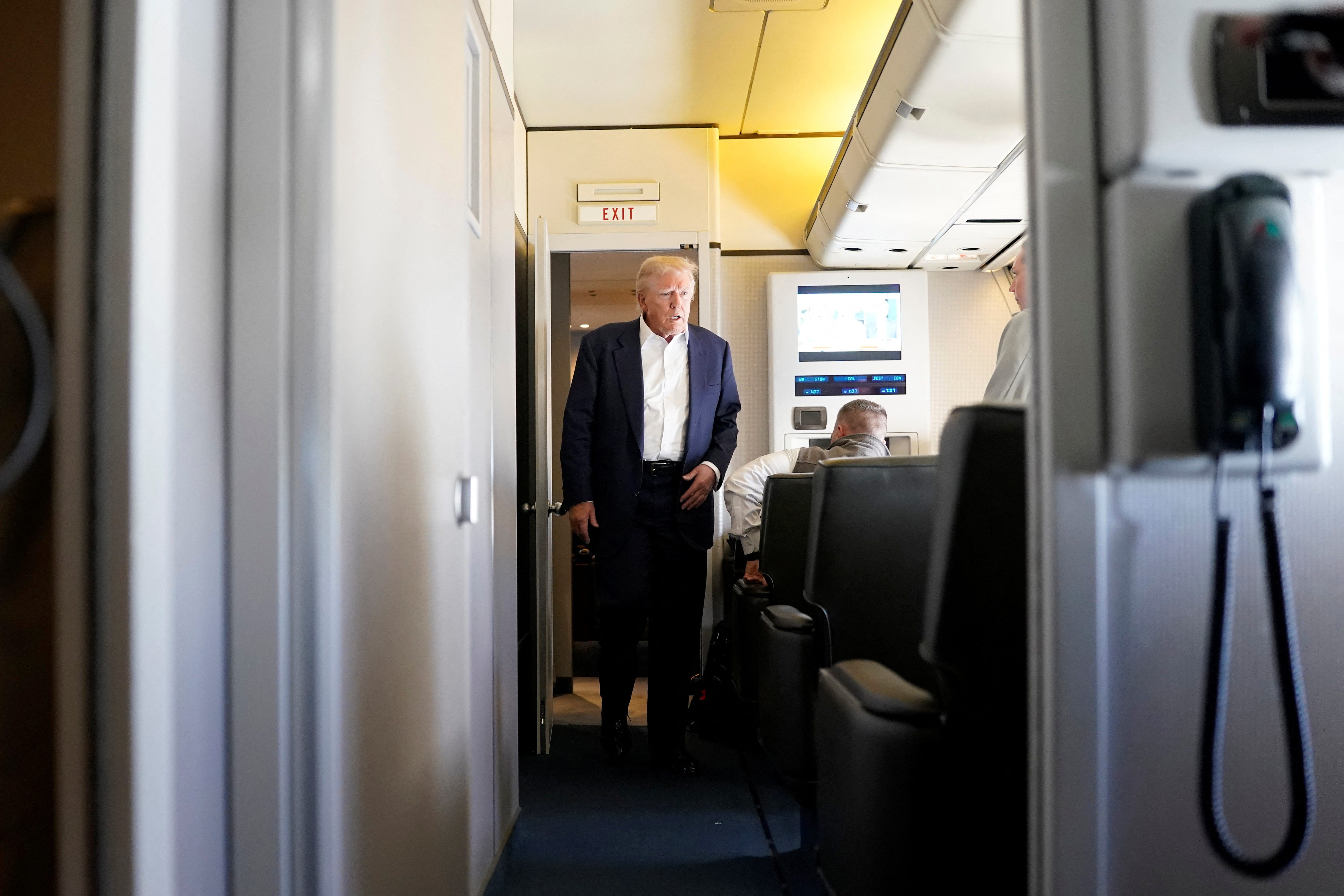 U.S President Donald Trump walks to speak to members of press onboard Air Force One on a flight to Fiumicino Airport near Rome to attend the funeral of Pope Francis, April 25, 2025.