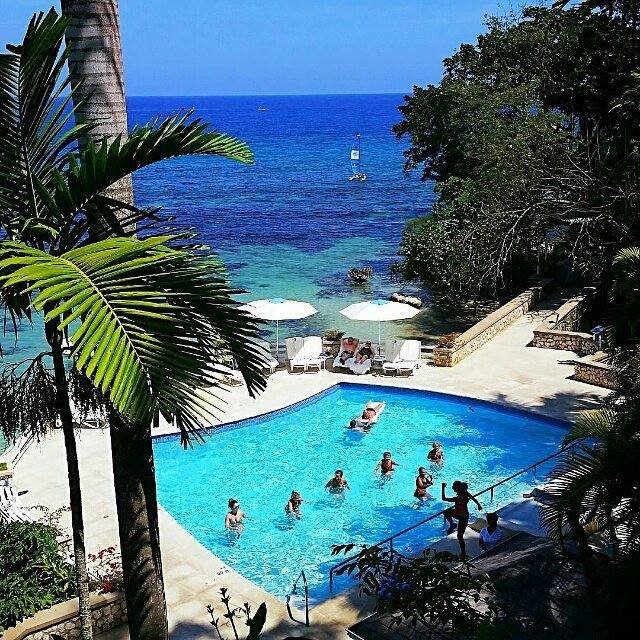 overview of a pool next to an ocean at a beach resort