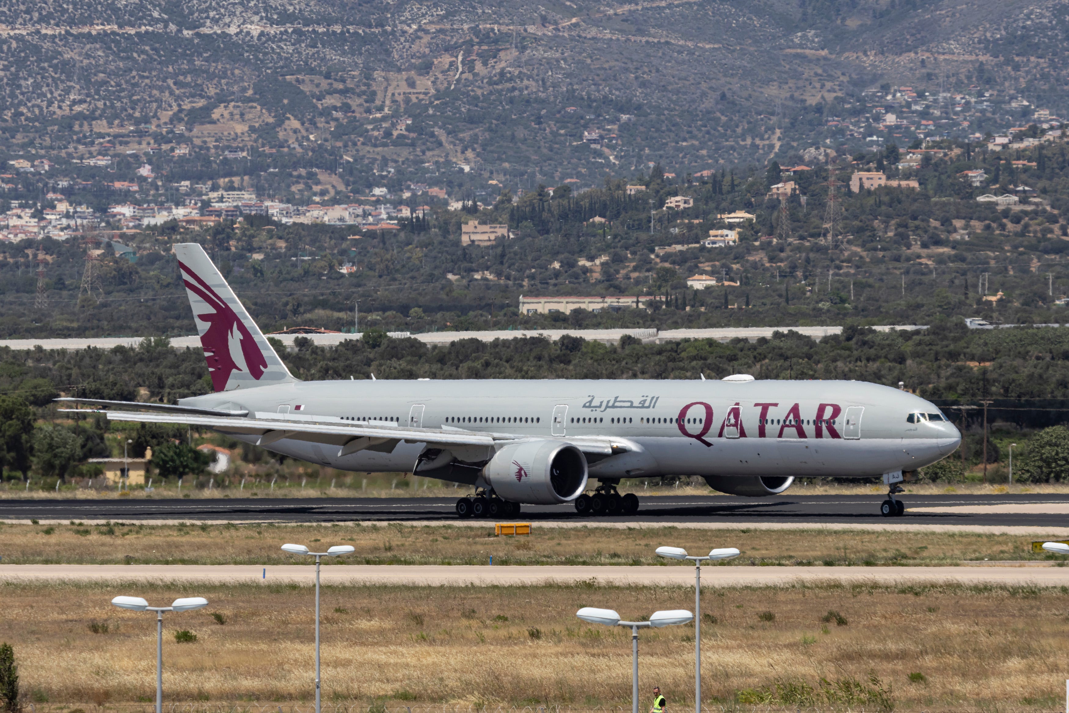 Qatar Airways Boeing 777-300ER passenger airplane as seen on final approach flying, landing and taxiing at Athens International Airport ATH in the Greek capital.