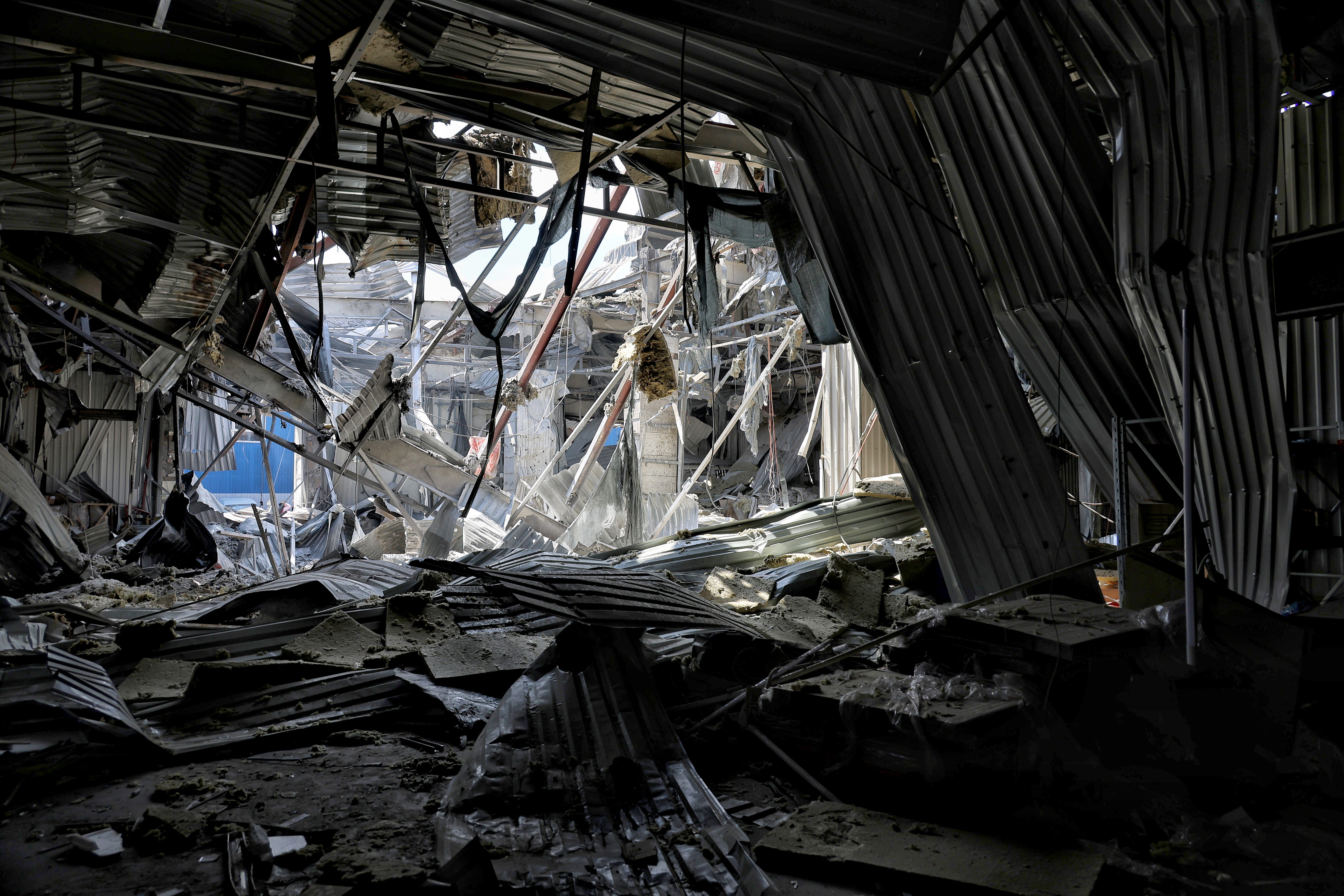 An interior view of a ruined building in Odesa, Ukraine, showing bent metal and collapsed supports, following a Russian attack in May 2025.