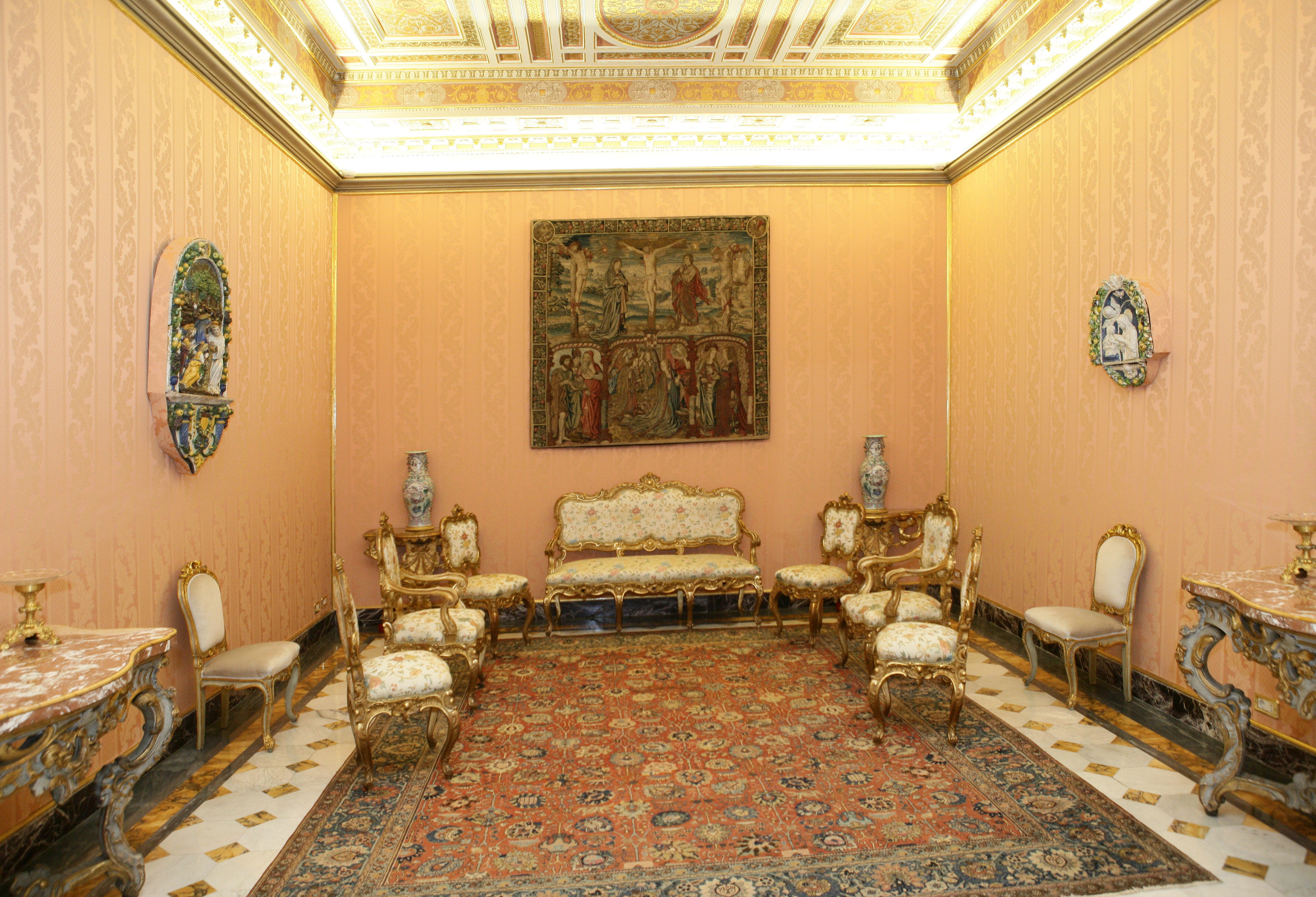 A room with yellow walls, an ornate ceiling, and antique furniture