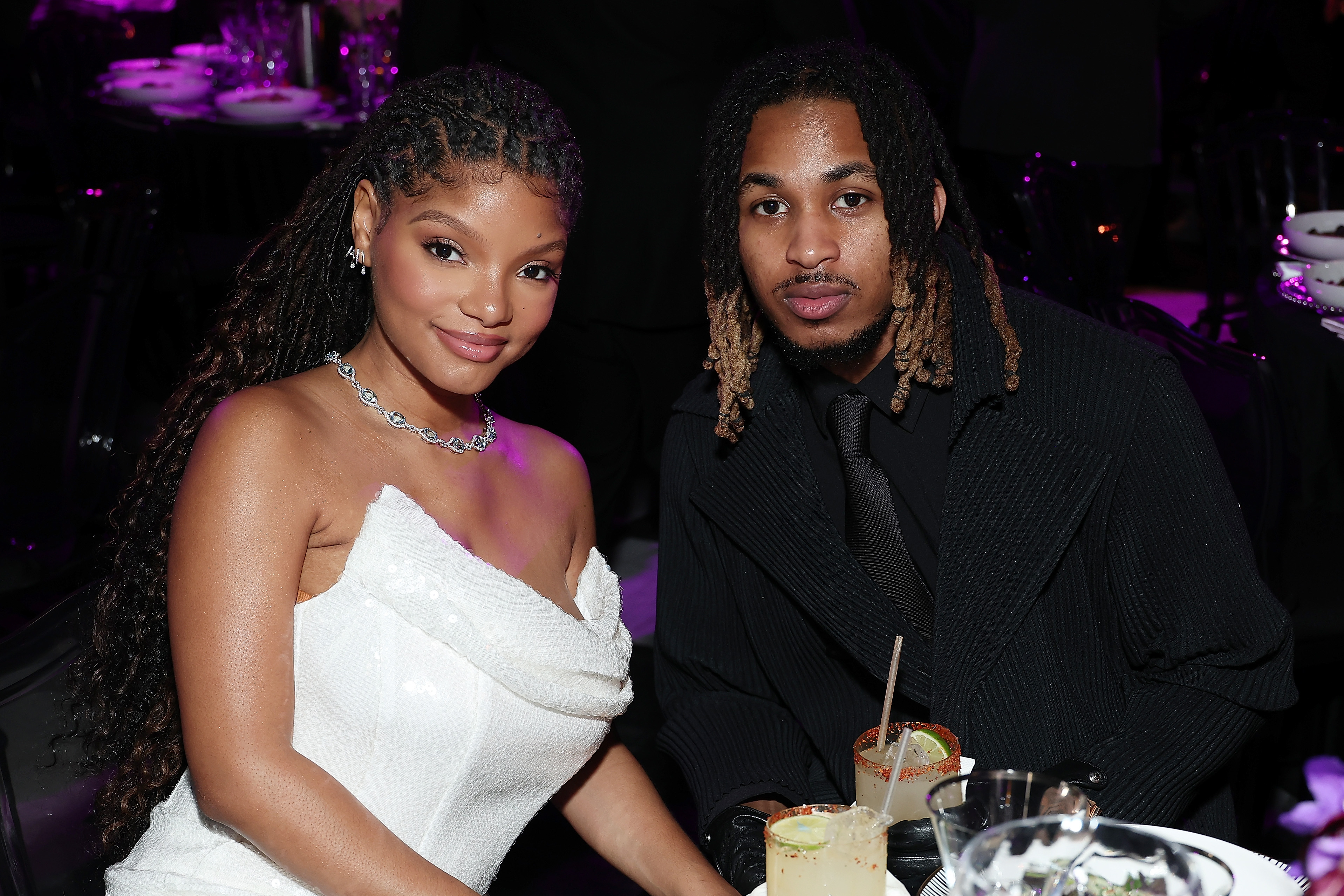 Halle Bailey and DDG sit at a table at an event. 