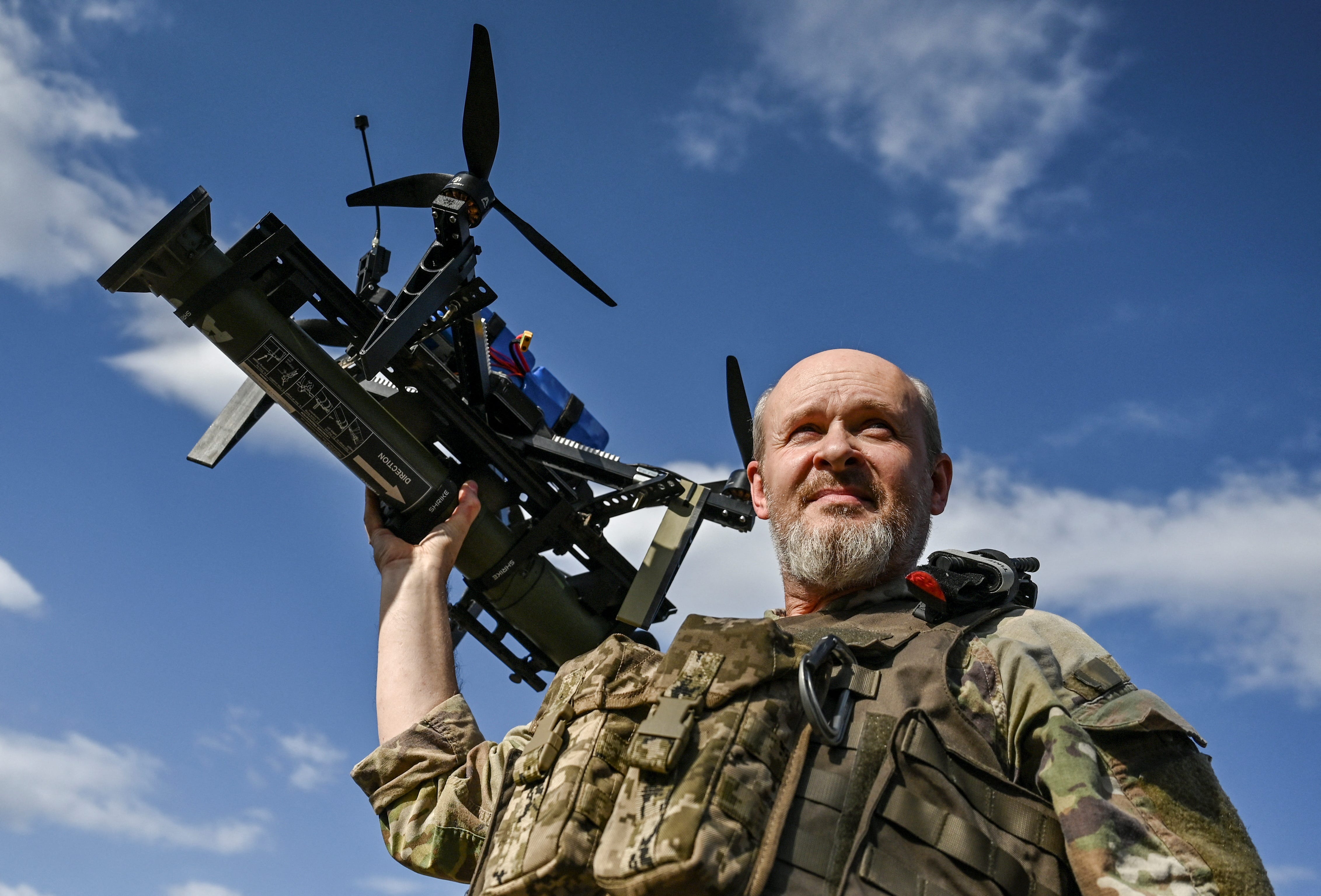 A Ukrainian serviceman of the 'Bulava' drone unit of the Separate Presidential Brigade carries an FPV drone with an attached portable grenade launcher.