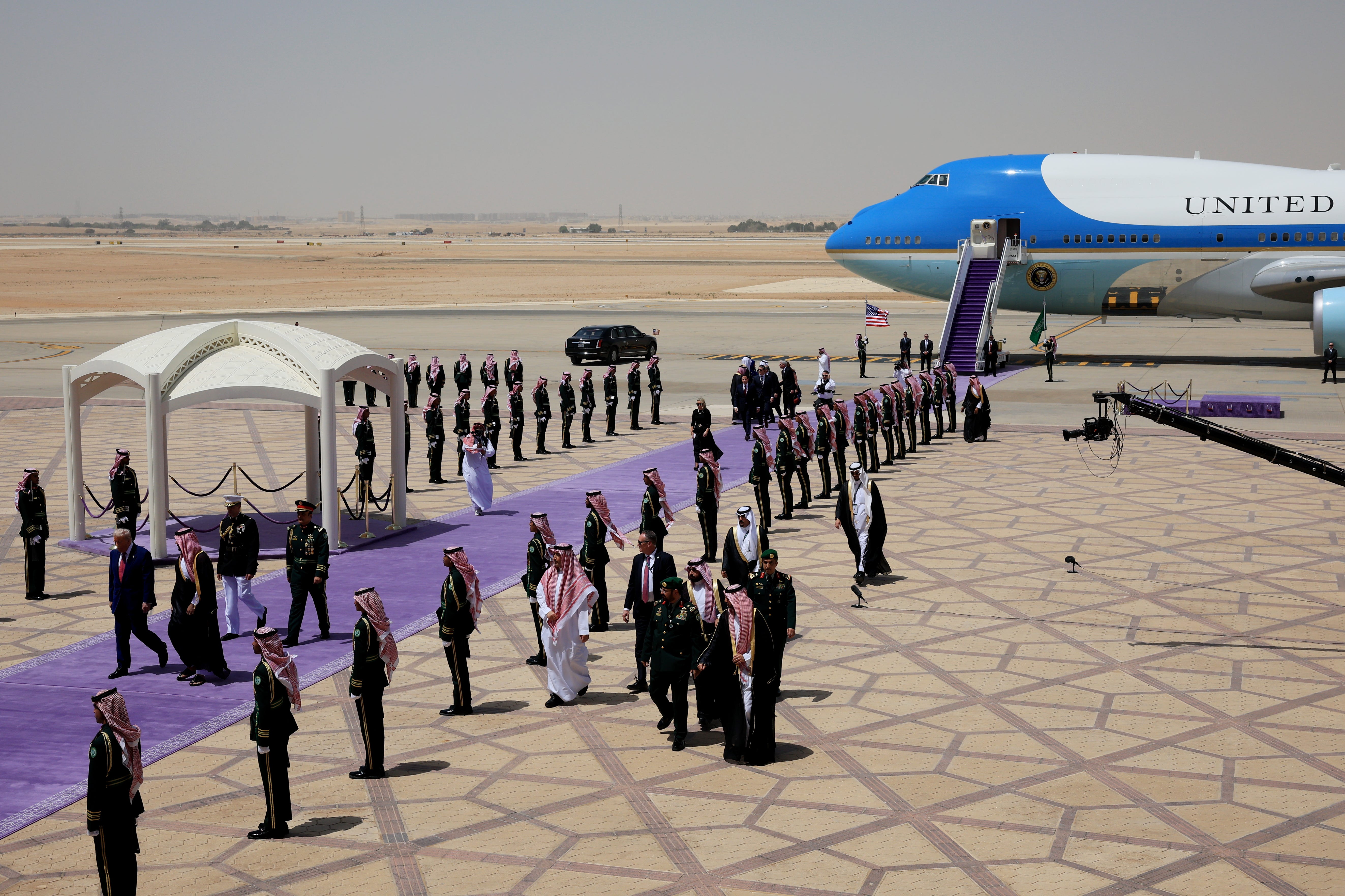 image of lavender carpet line of representatives greeting Trump plane