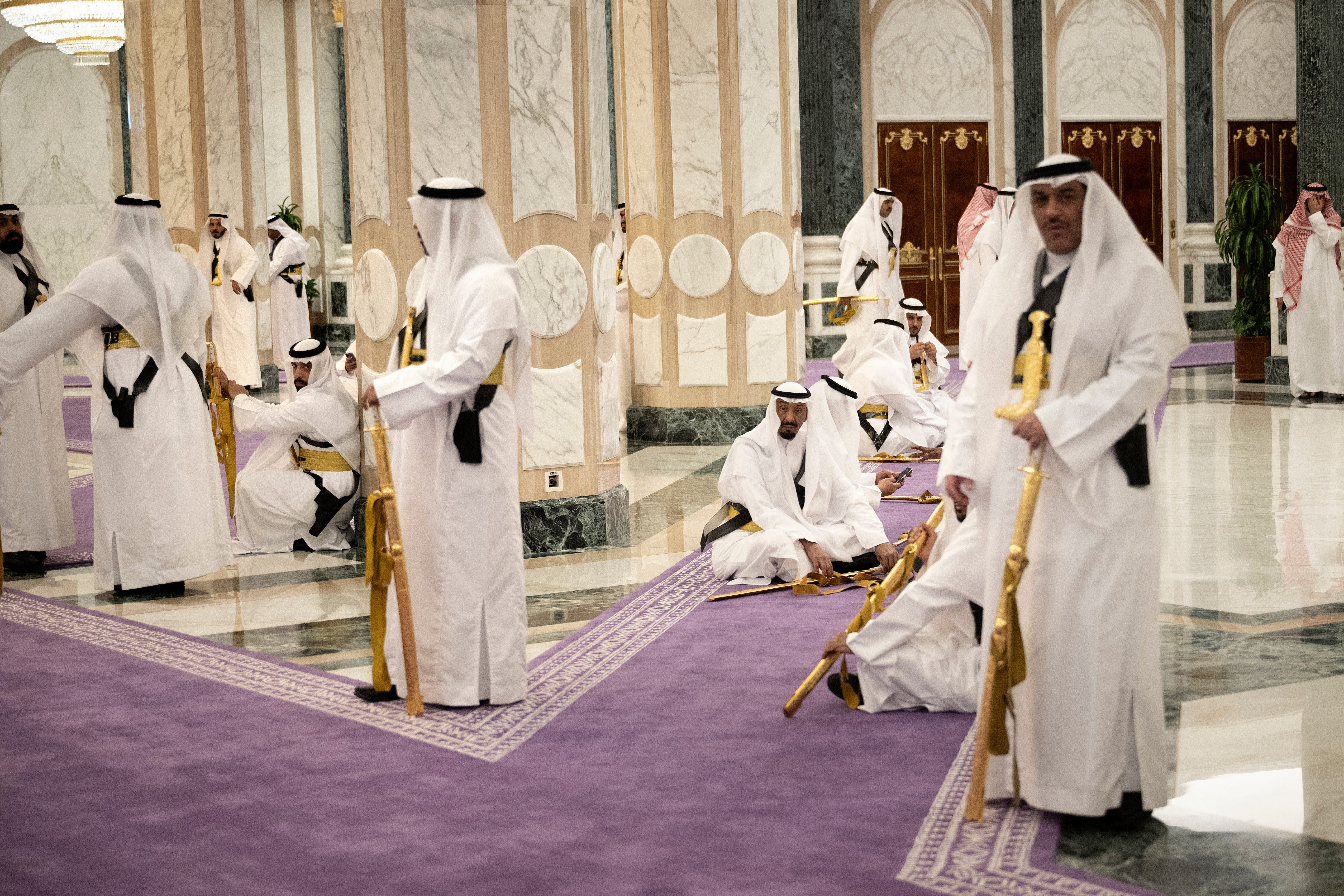 image of men in dressed in white holding golden swords on purple carpet