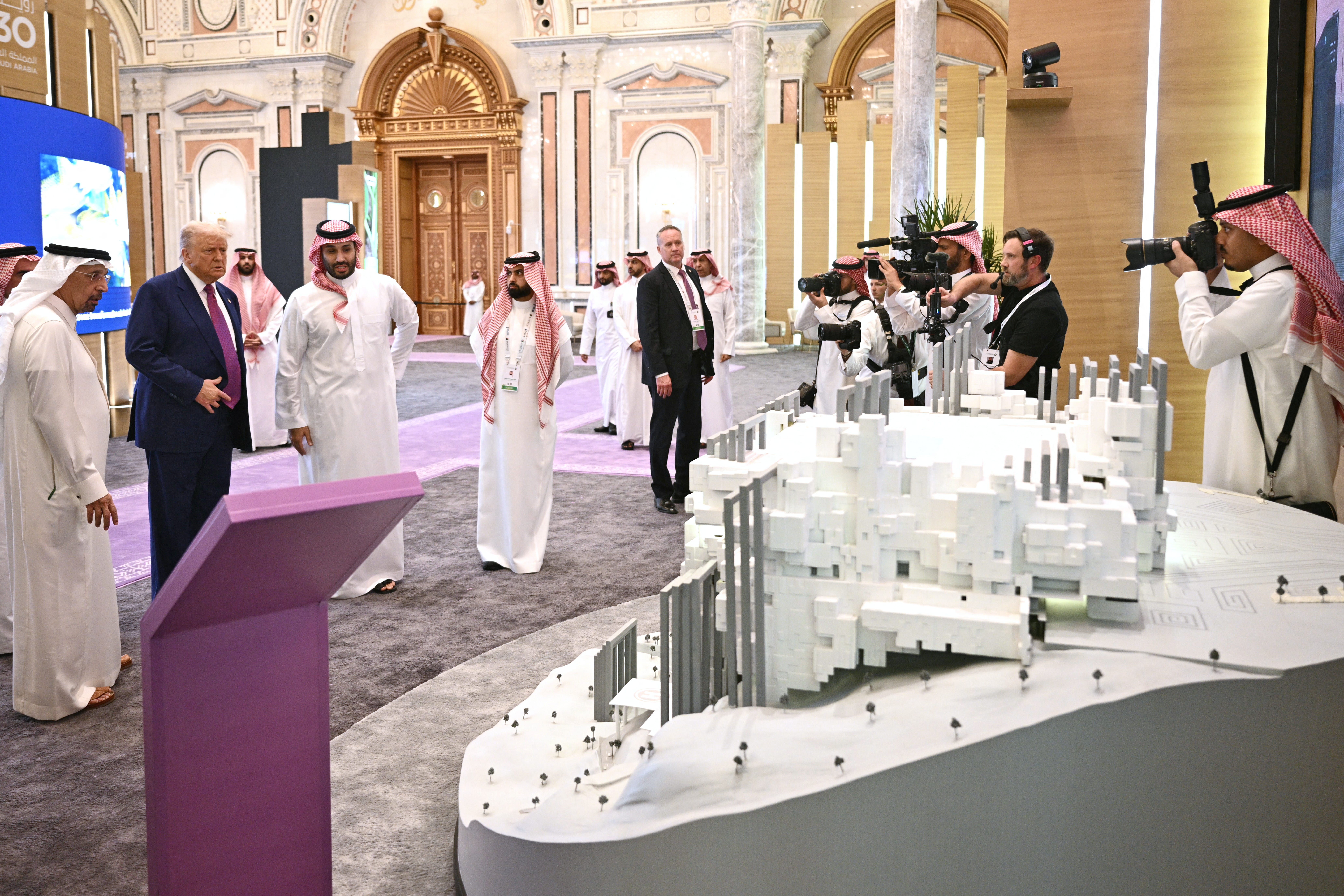 image of trump and crown prince looking at exhibits in conference center