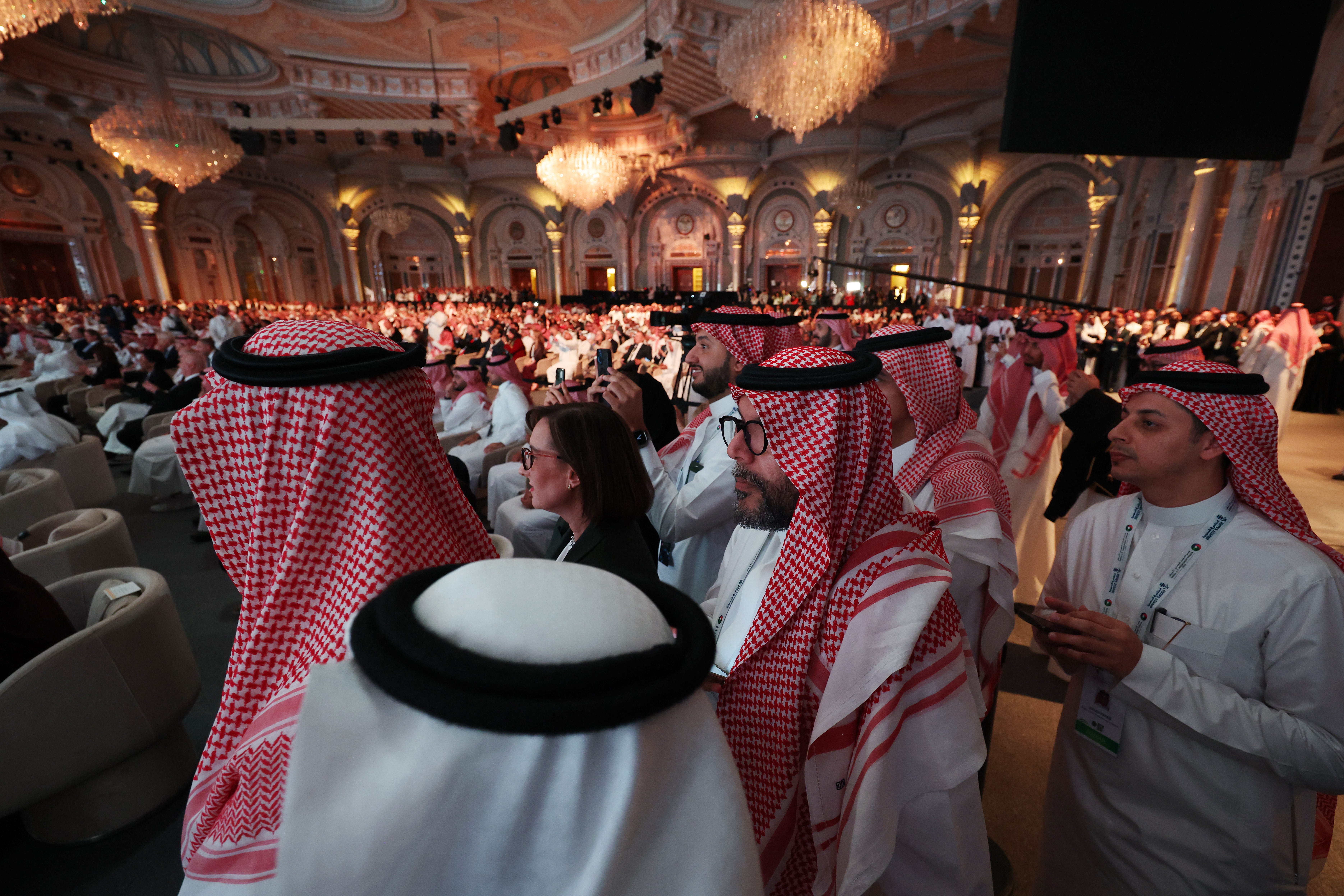 image of audience members in ornate chandelier-ed room