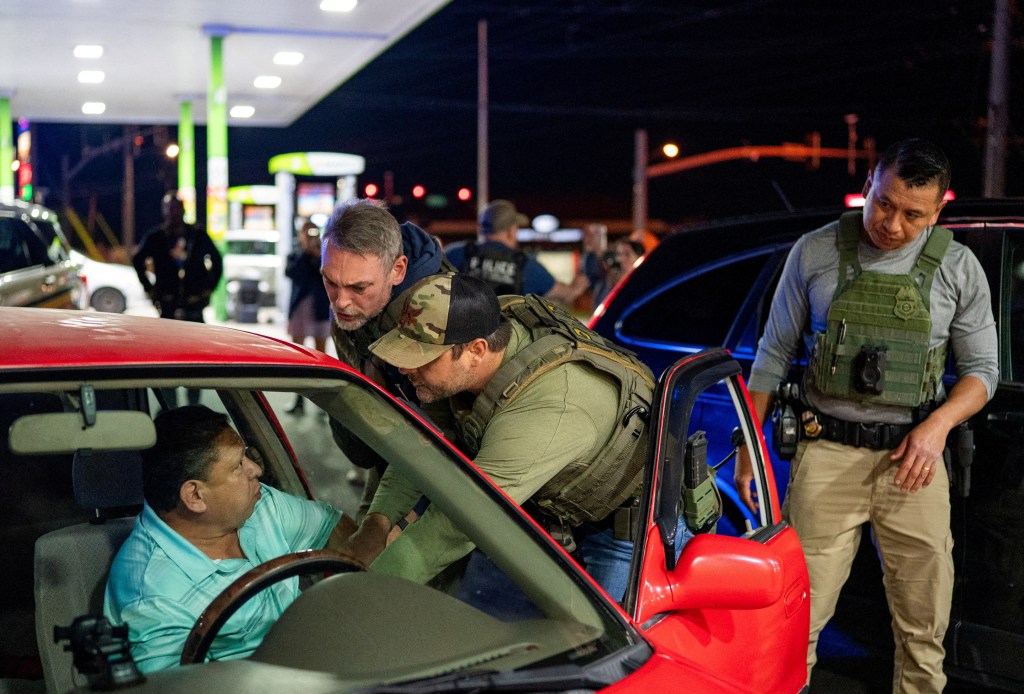 U.S. Immigration and Customs Enforcement (ICE) officers detain a man stopped by Tennessee Highway Patrol (THP) at a gas station in South Nashville as he could not produce any alternative identification proof other than his expired driving license, during an operation conducted by ICE along with THP to detain noncitizens across the city of Nashville, Tennessee, U.S., May 10, 2025. 
