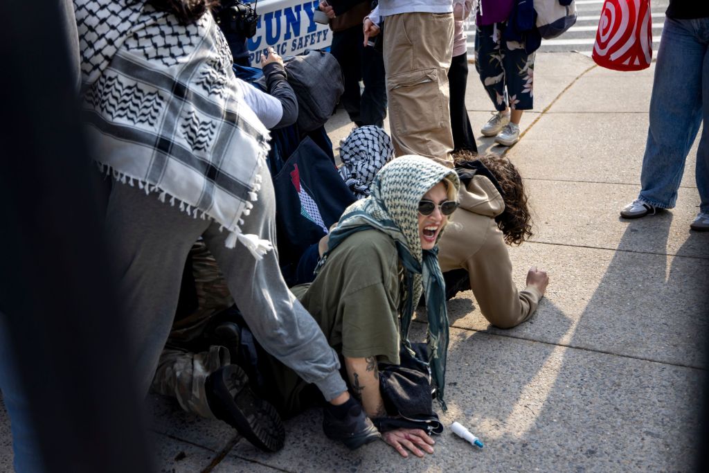 Protesters on the ground blocking a security car during a pro-Palestine encampment at Brooklyn College, New York in May 2025