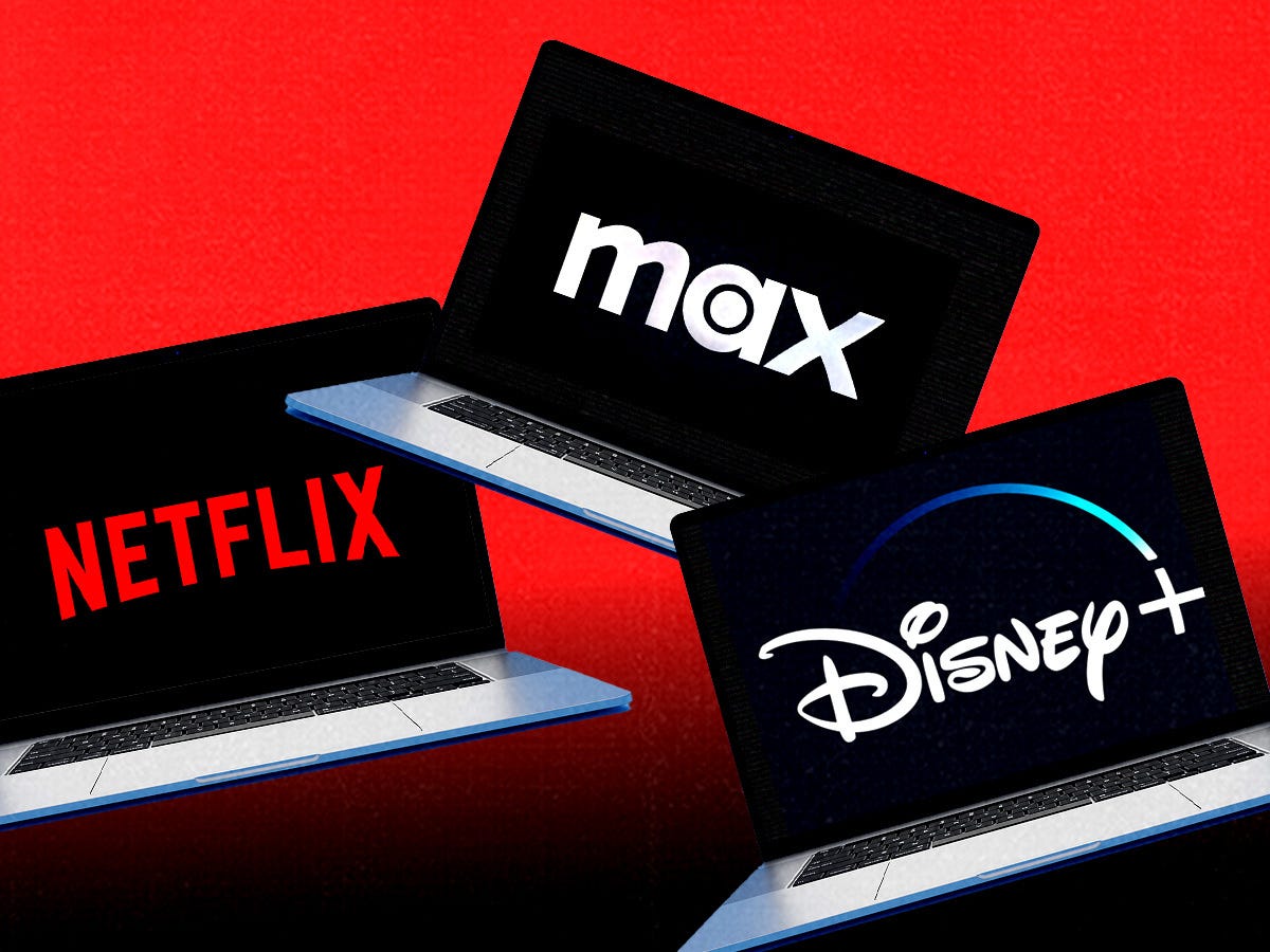 Three laptops with the Netflix, Max and Disney logos on their screens, in front of a red background.