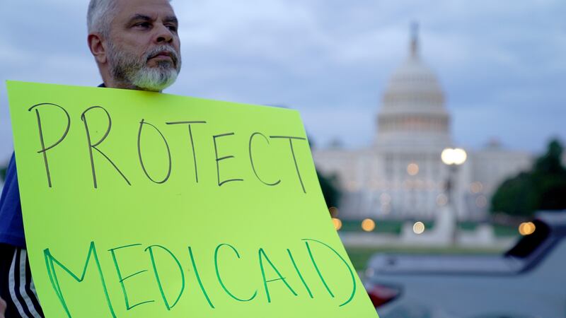 A protestor holds a sign reading "protect Medicaid" outside the U.S. Capitol in Washington, DC.