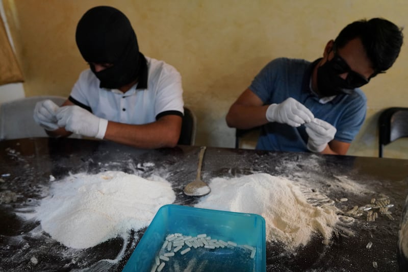 Members of the Sinaloa Cartel prepare capsules with methamphetamine in a safe house in Culiacan, Mexico, April 4, 2022.