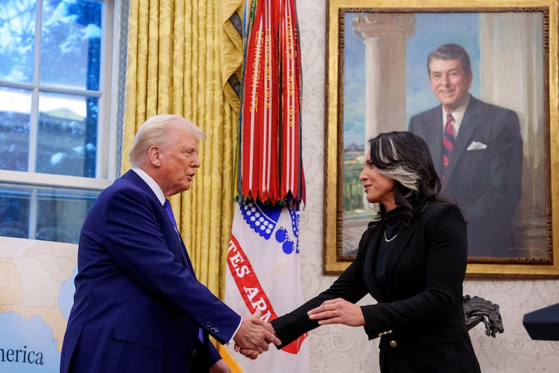 Director of National Intelligence Tulsi Gabbard shakes hands with President Donald Trump in the Oval Office at the White House on Feb. 12, 2025.
