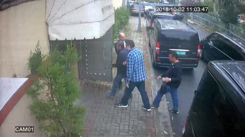 A group of men entering a side door apparently from black minivans