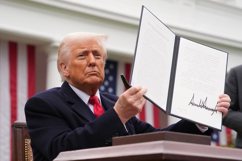 President Donald Trump displays a signed executive order imposing tariffs on imported goods during a “Make America Wealthy Again” trade announcement.
