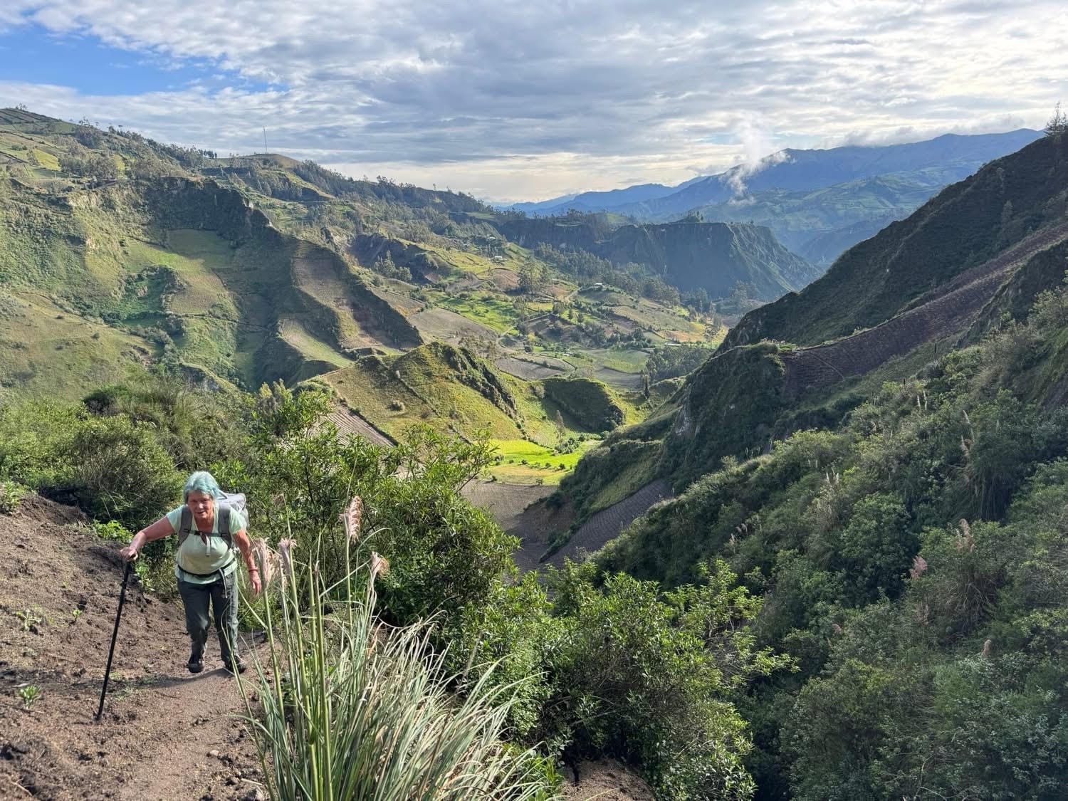 The author hiking up a steep sandy hill in Ecuador.
