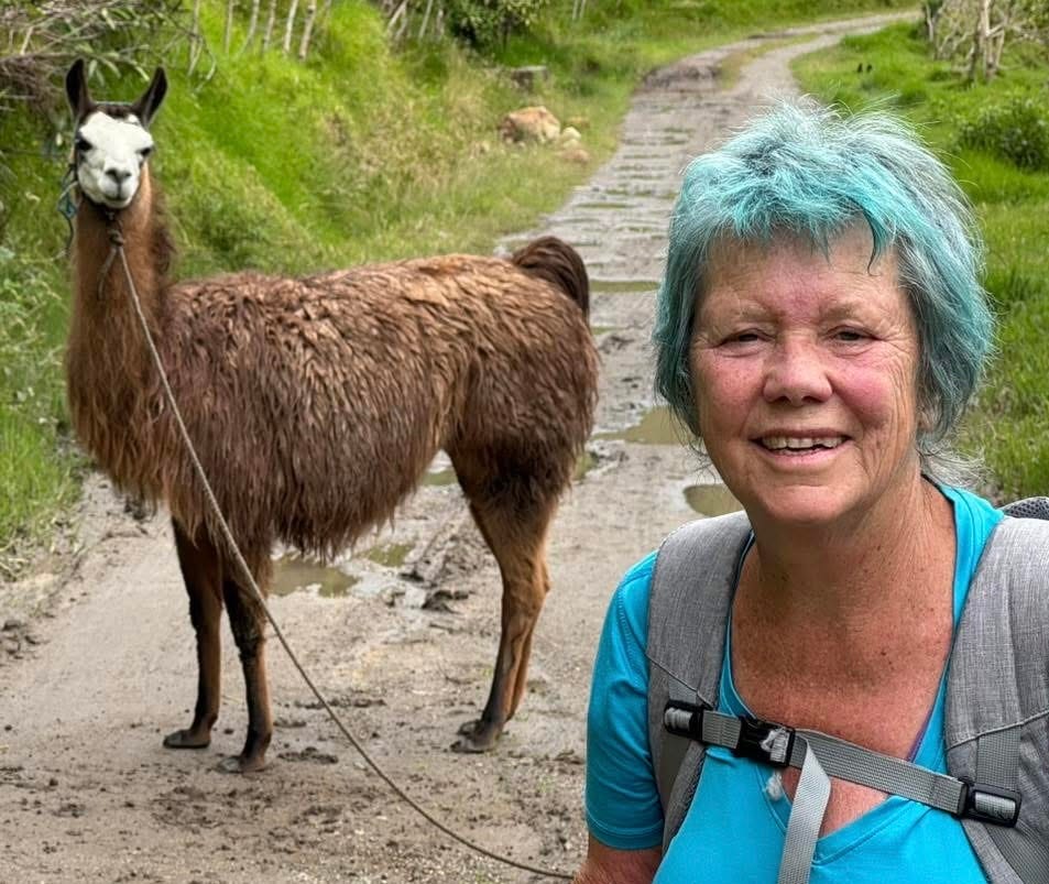 The author with a llama while hiking on a trail.