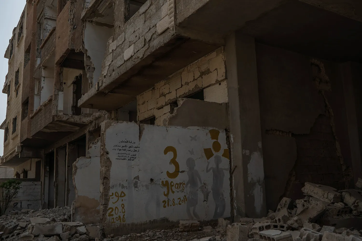 Graffiti on a wall in a destroyed neighborhood marks the three-year anniversary of the 2013 attack.