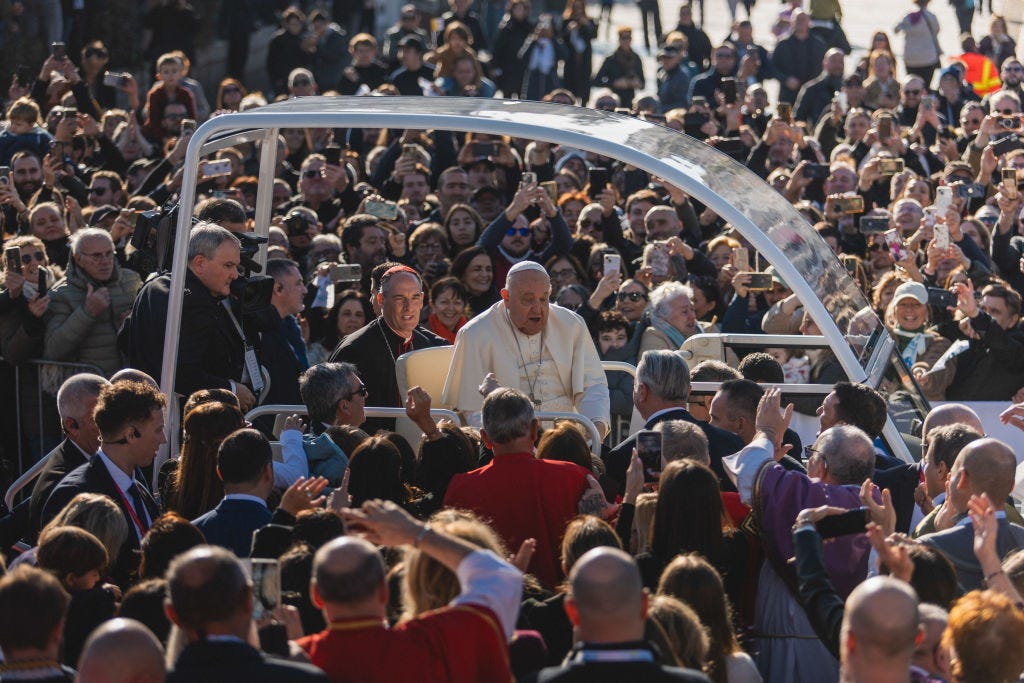 Pope Francis rides the popemobile through a crowd.
