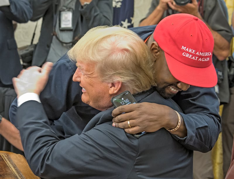 Kanye West embraces real estate developer and US President Donald Trump in the White House's Oval Office, Washington DC, October 11, 2018.
