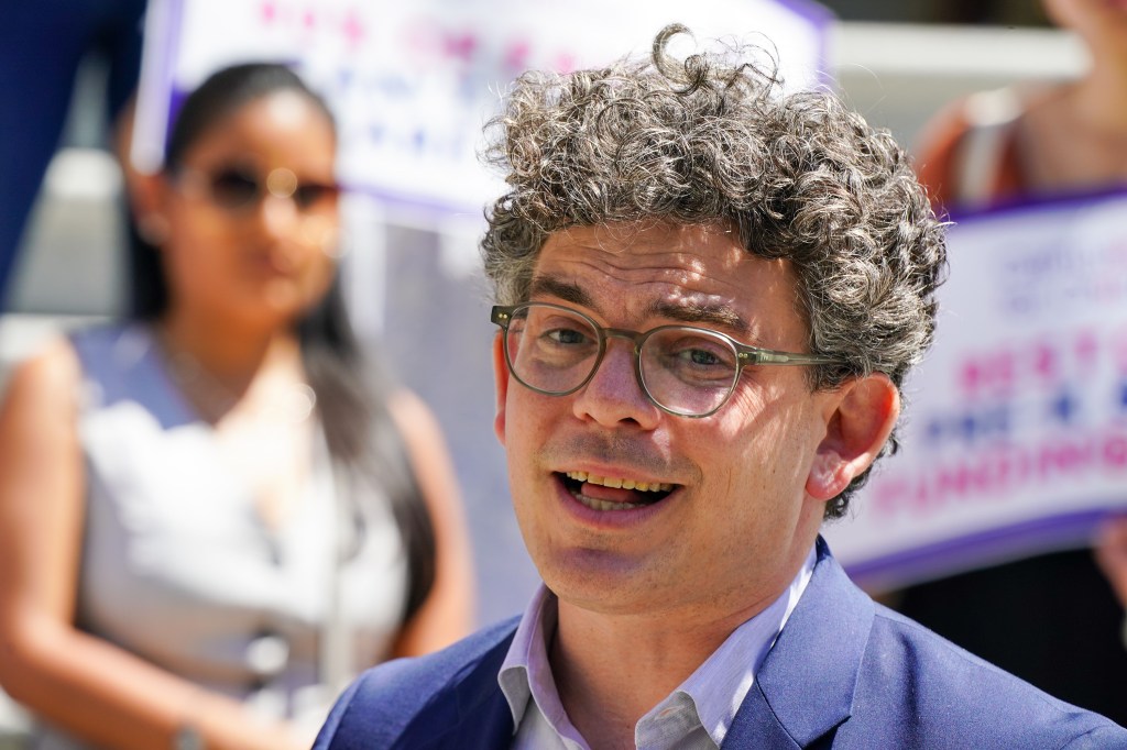 Lincoln Restler at a City Hall press conference with council members advocating for increased Pre-K education funding, children, and bubbles in the background.
