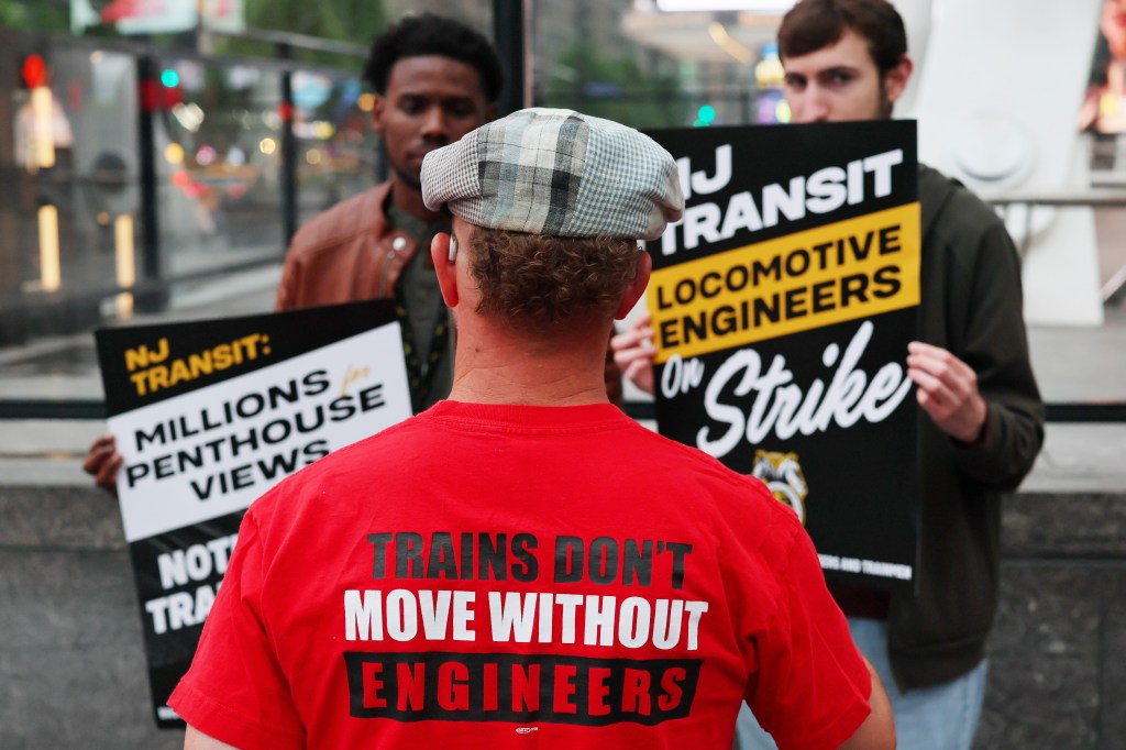 Members of the railroad engineers union hold signs outside of Penn Station on May 16, 2025 in New York City.