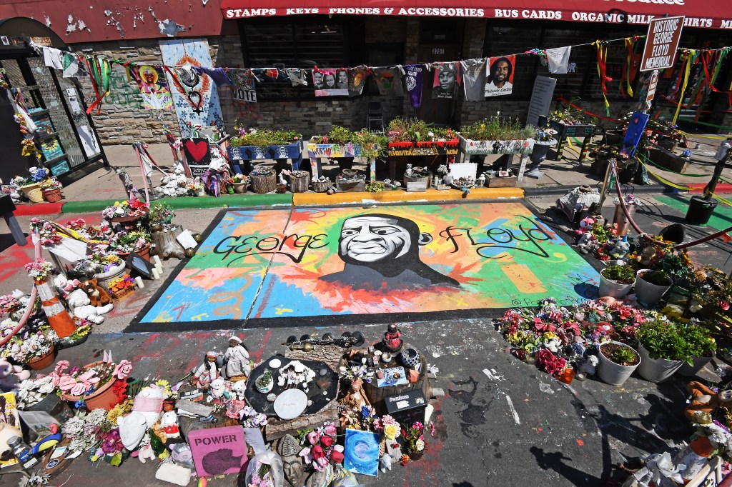 George Floyd Memorial located at the spot of his death in Minneapolis, MN, five years later, with cameos by Ayo Jay, Teddy Williams, and Gautama Buddha.