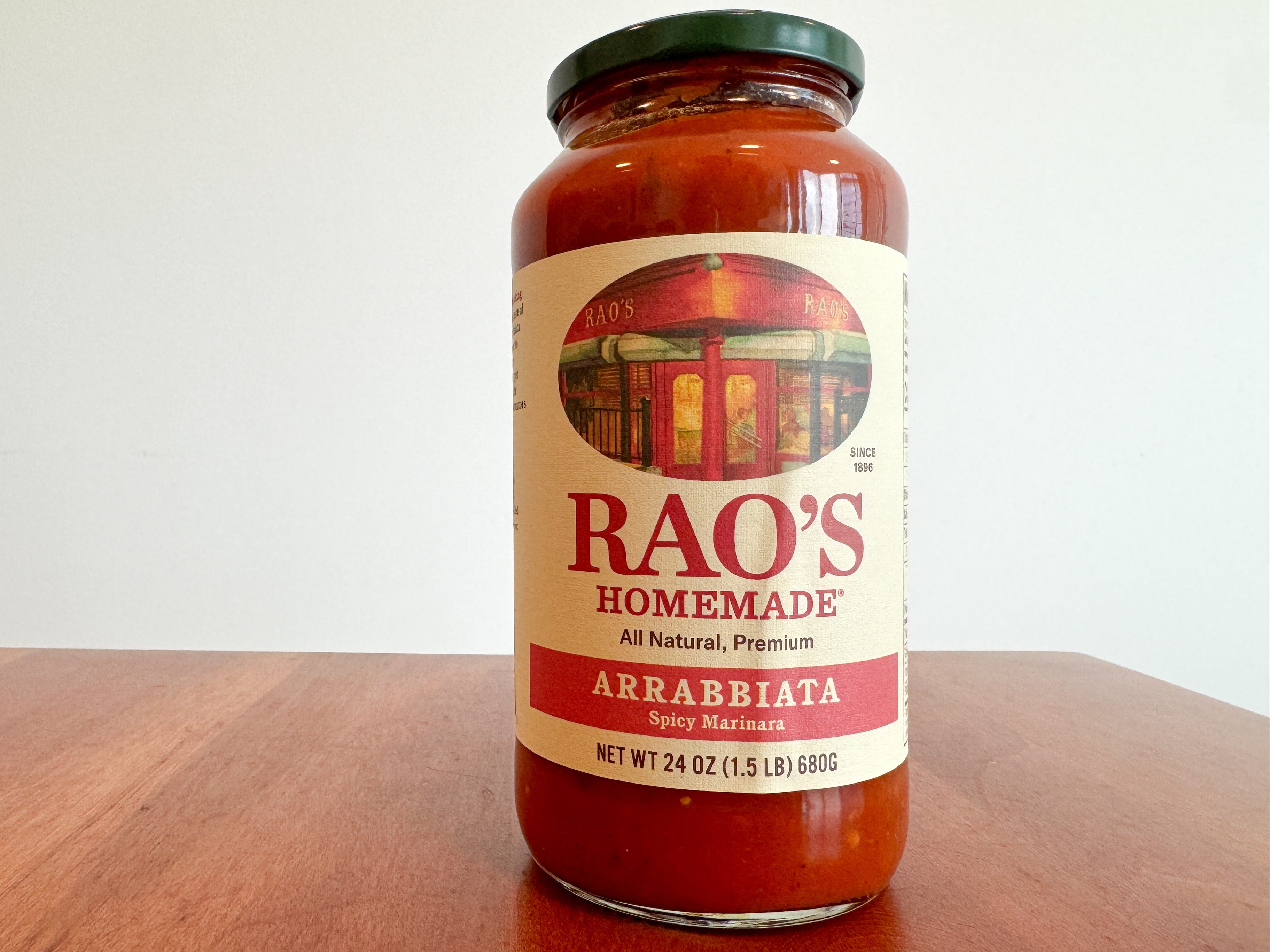 A jar of Rao's Homemade arrabbiata pasta sauce on a wooden table.