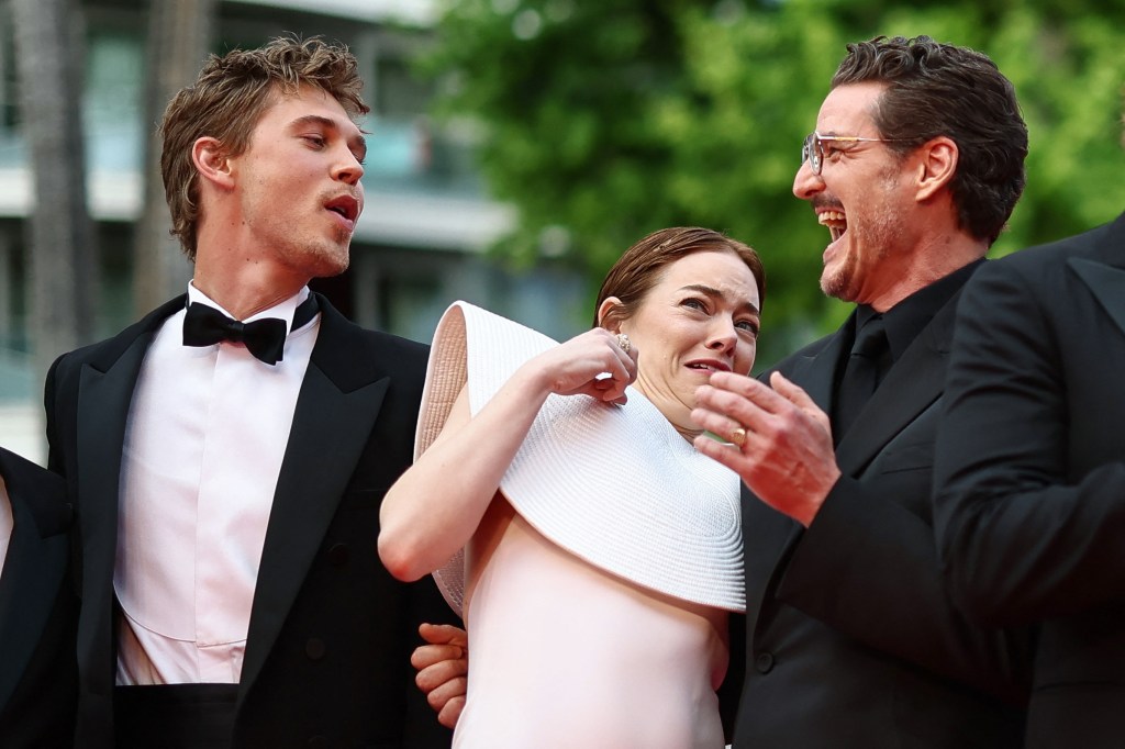 Emma Stone being attacked by a bee while posing with Austin Butler and Pedro Pascal at the Cannes Film Festival Friday. 