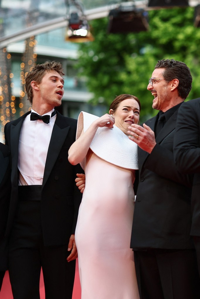 Emma Stone being attacked by a bee while posing with Austin Butler and Pedro Pascal at the Cannes Film Festival Friday. 