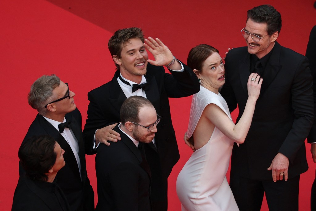 Emma Stone being attacked by a bee while posing with Austin Butler and Pedro Pascal at the Cannes Film Festival Friday. 