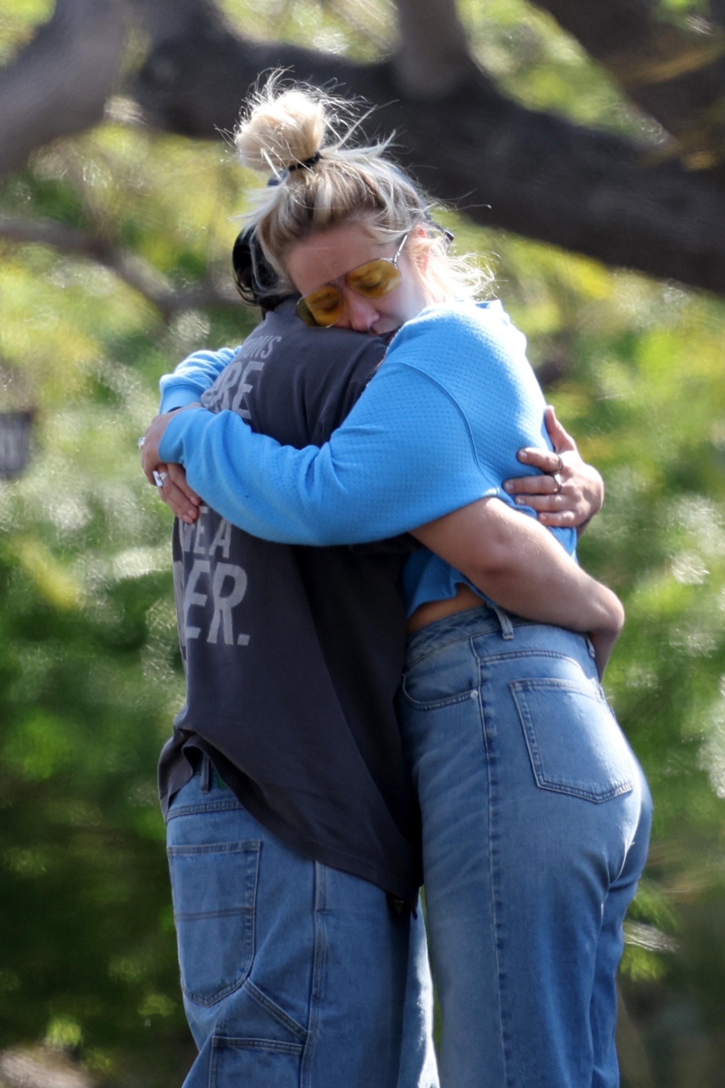Anna Camp and Jade Whipkey hugging outdoors. 