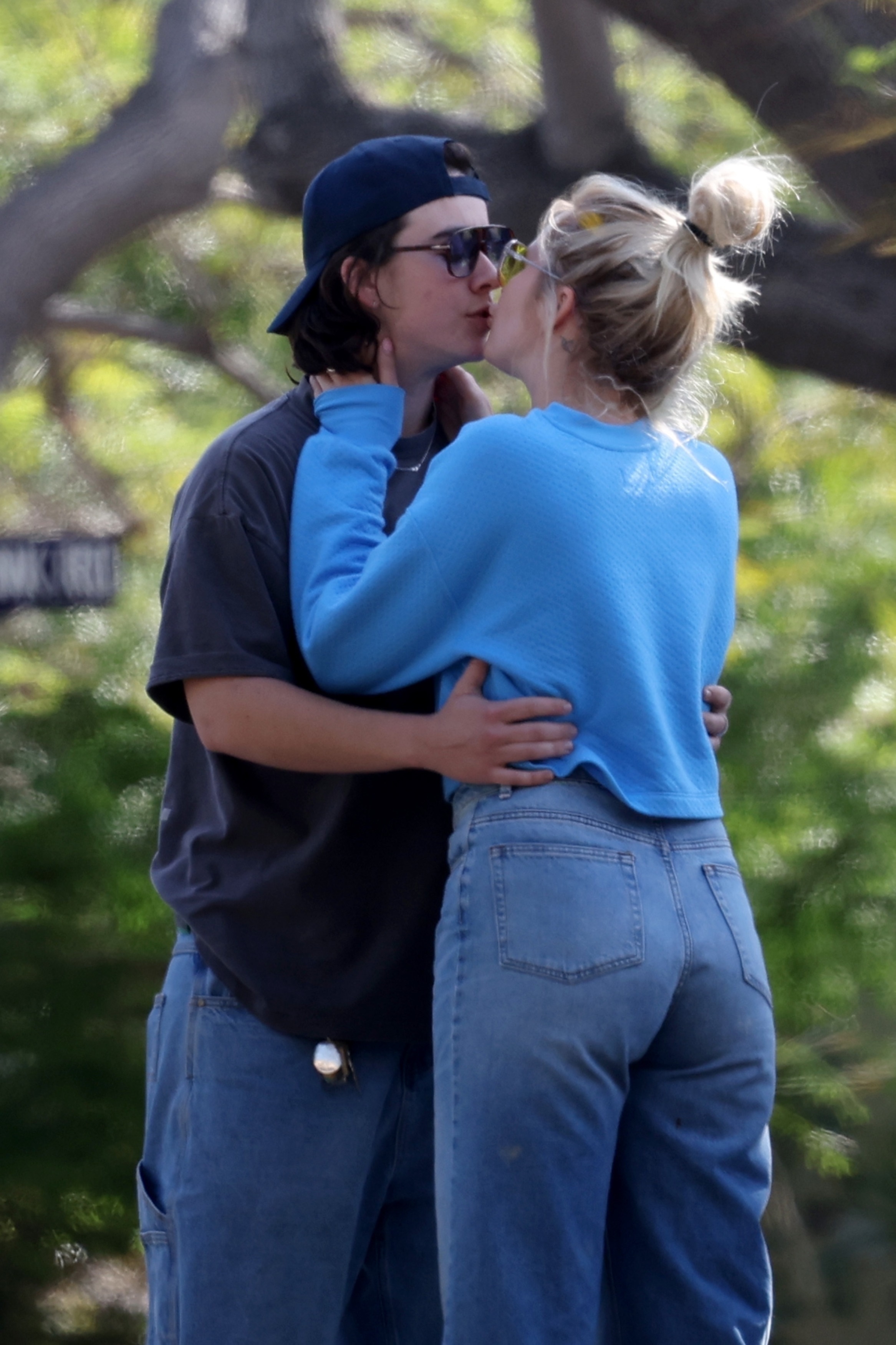 Anna Camp and Jade Whipkey kissing under a tree. 