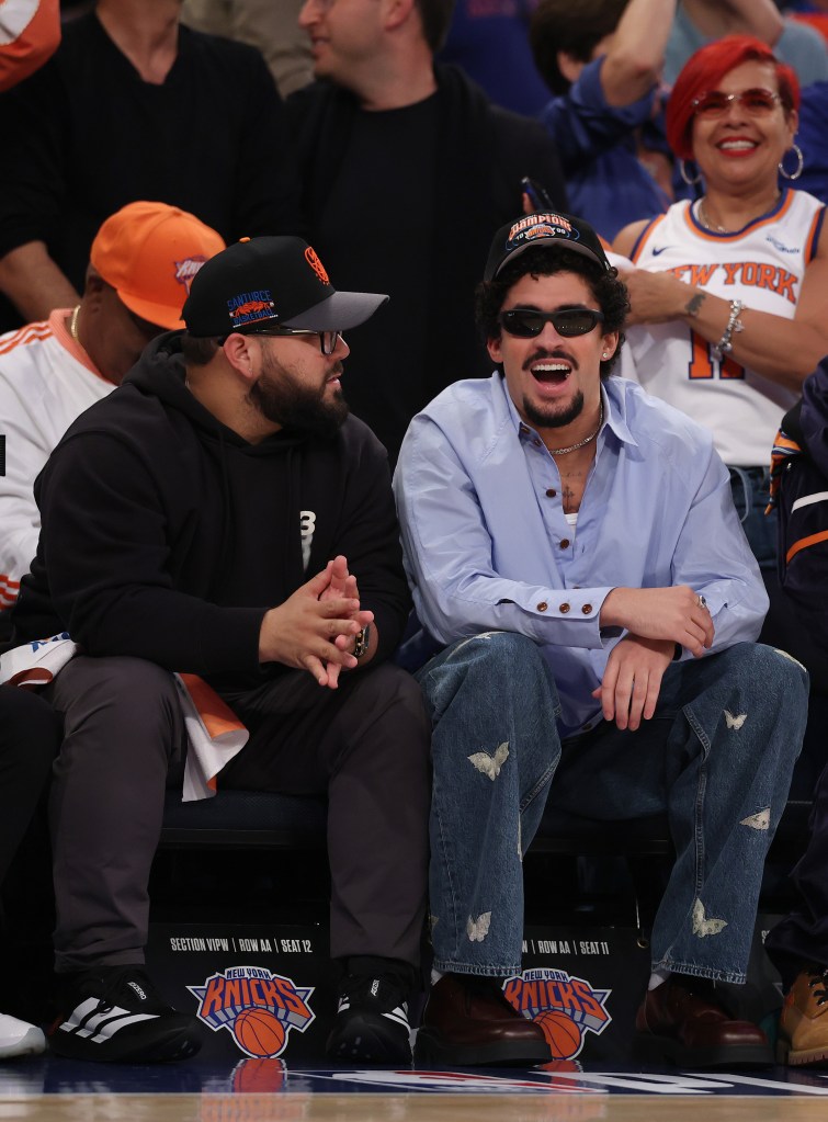 Bad Bunny, right, smiles in the first quarter of Game Six of the Eastern Conference Second Round NBA Playoffs between the New York Knicks and the Boston Celtics at Madison Square Garden