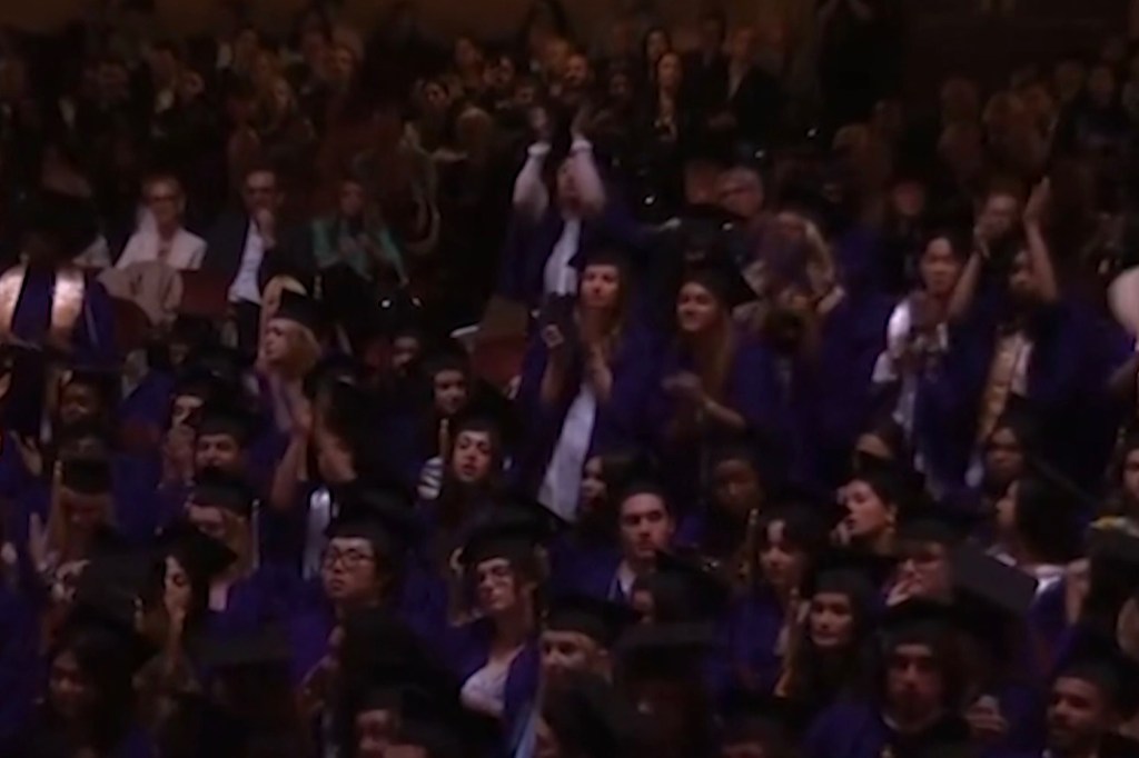 Graduating NYU students react during Rozos' address.