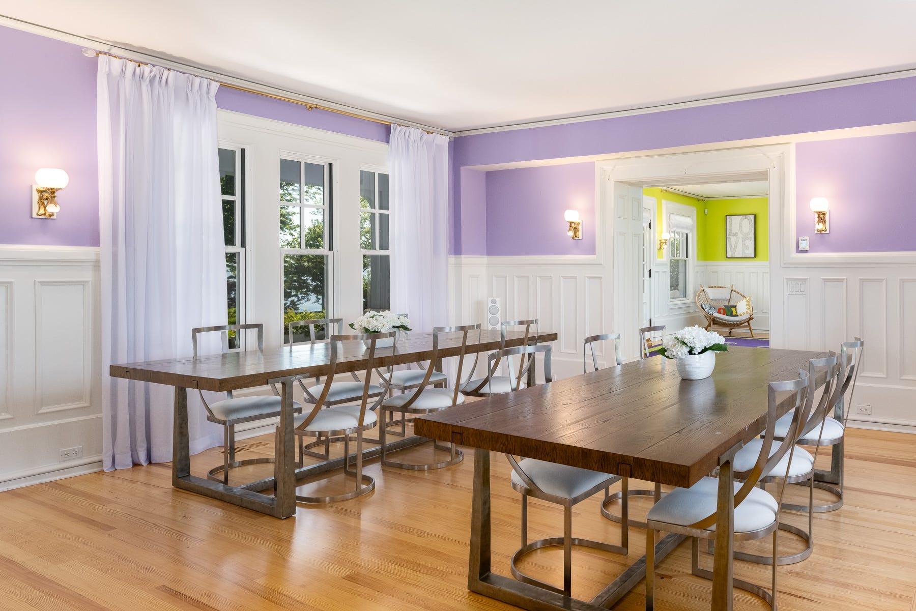 A dining area with two tables and purple walls.