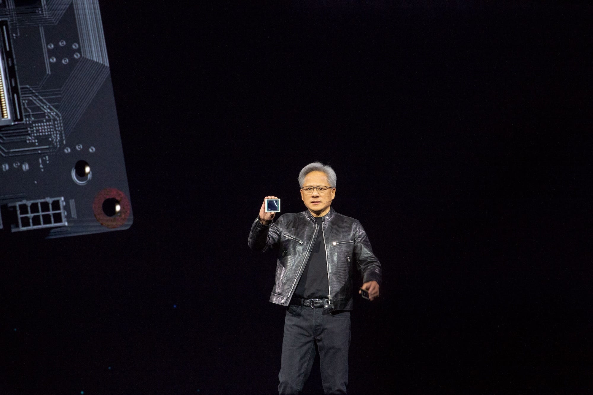 Nvidia's Jensen Huang holds up one of the company's Blackwell chips at the 2024 GTC conference.