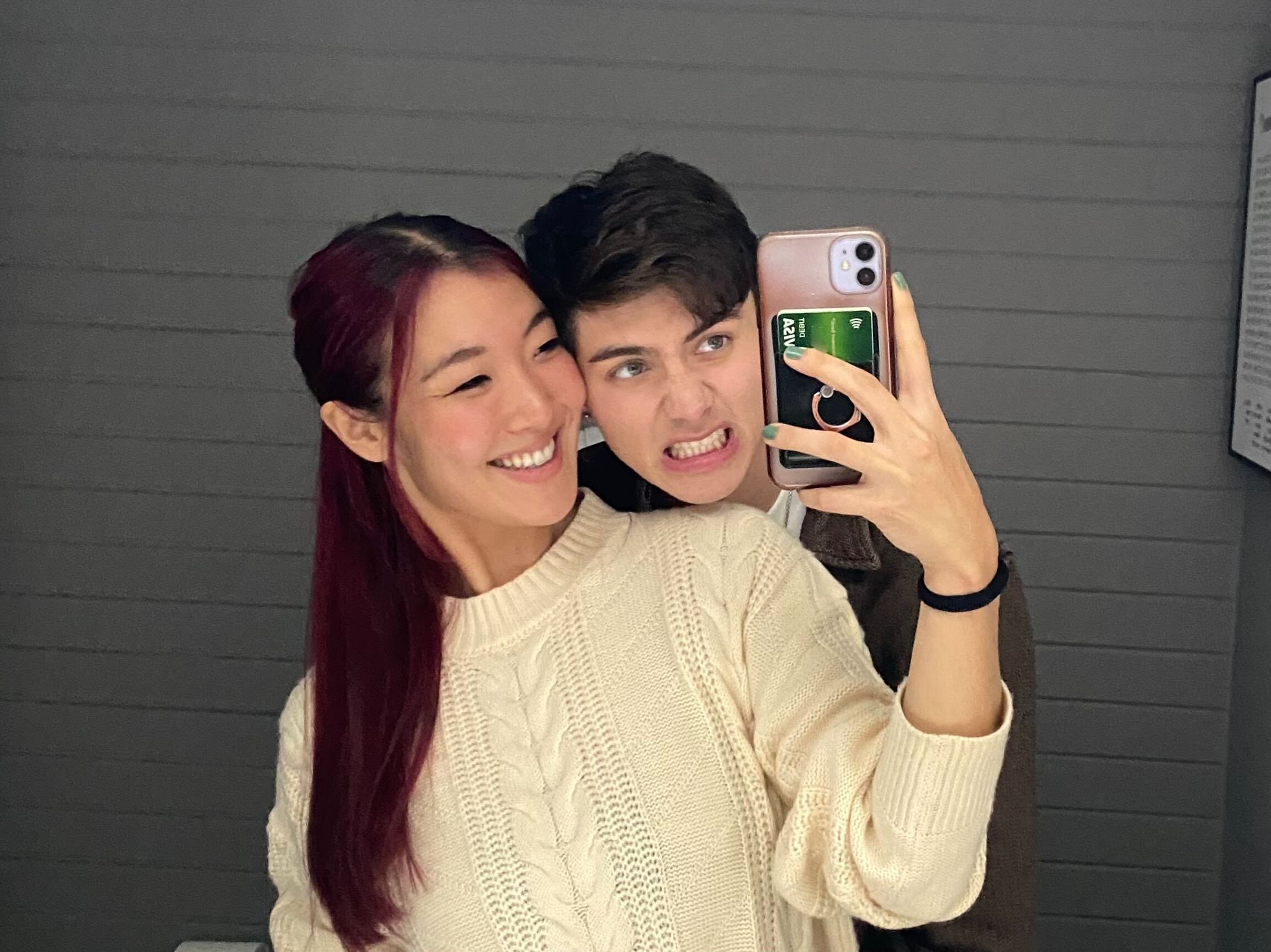 The author and her boyfriend taking a selfie in the mirror and smiling.