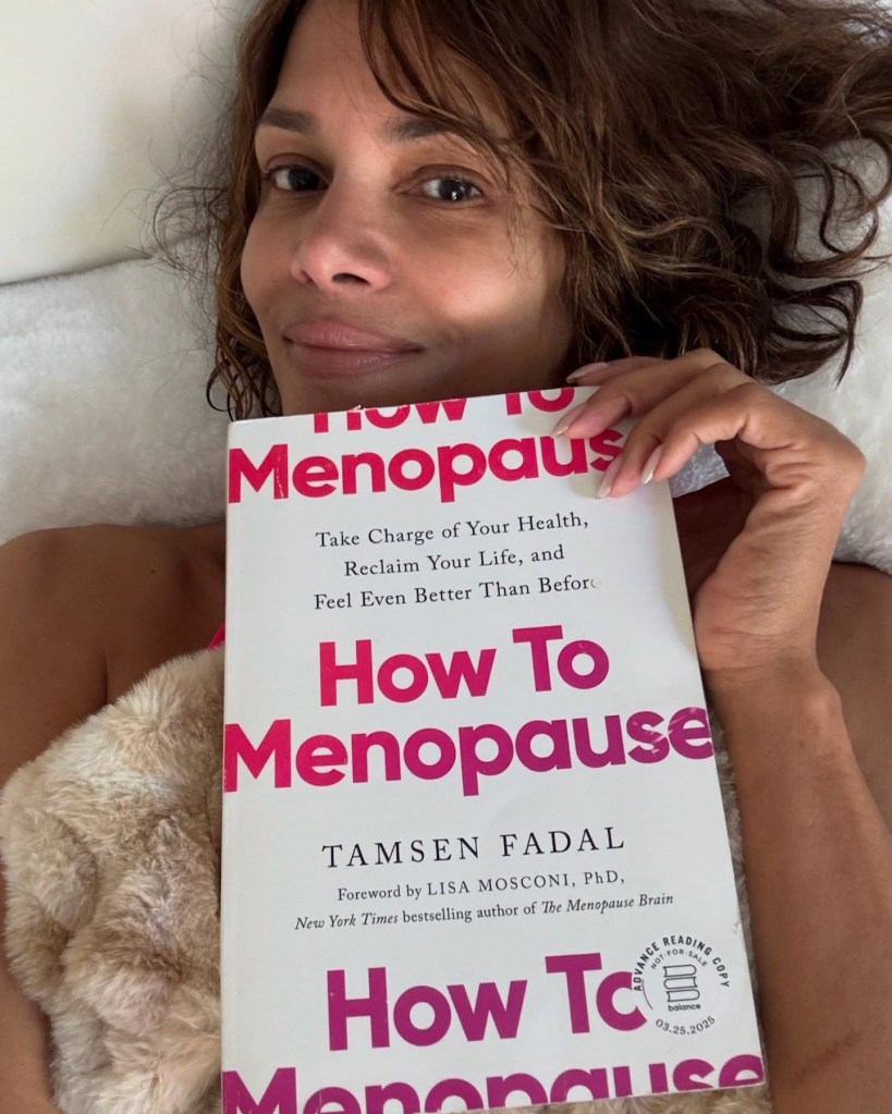 Halle Berry holds up a copy of 'How to Menopause' by Tamsen Fadal.