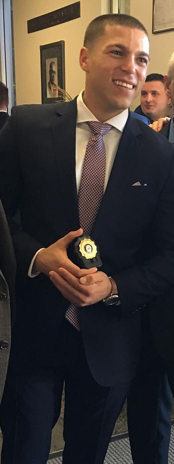 A photo of Nick Galante receiving his firefighters badge.