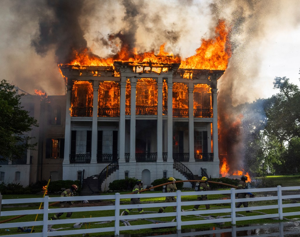 Fire crews working around the fully engulfed Nottoway Plantation house in White Castle, Louisiana on May 15, 2025. seen here flames engulf the entire top floor of the manse