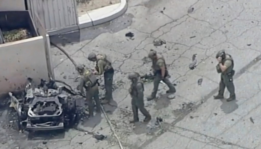 Law enforcement officials investigating the destroyed vehicle.