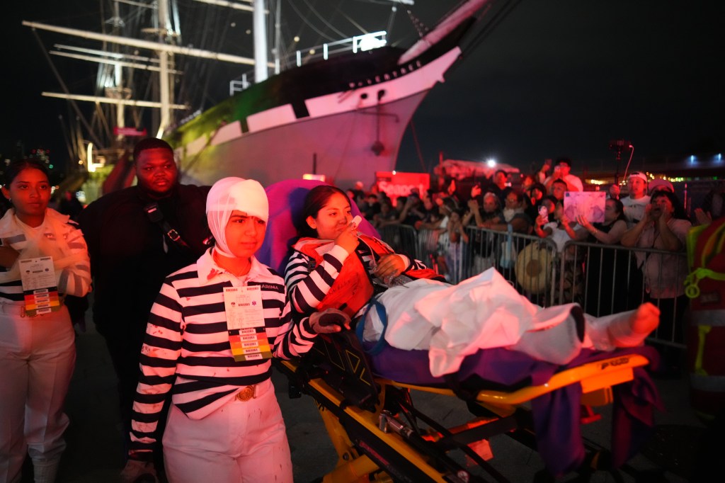 injured crewmembers including one seen with their head wrapped ina. bandage and another on a stretcher