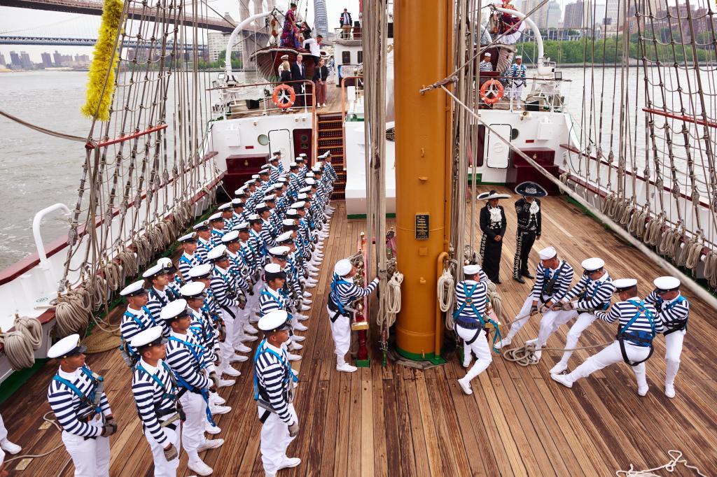 crewmembers in white hats, blue and white shirts and white pants on the deck of the Cuauhtémoc after the Mexican vessel slam