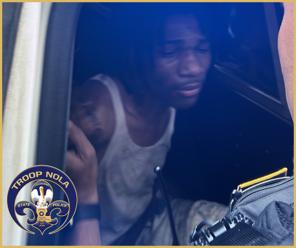 Kendall Myles sits in the back of a police car after being captured by on Royal Street.