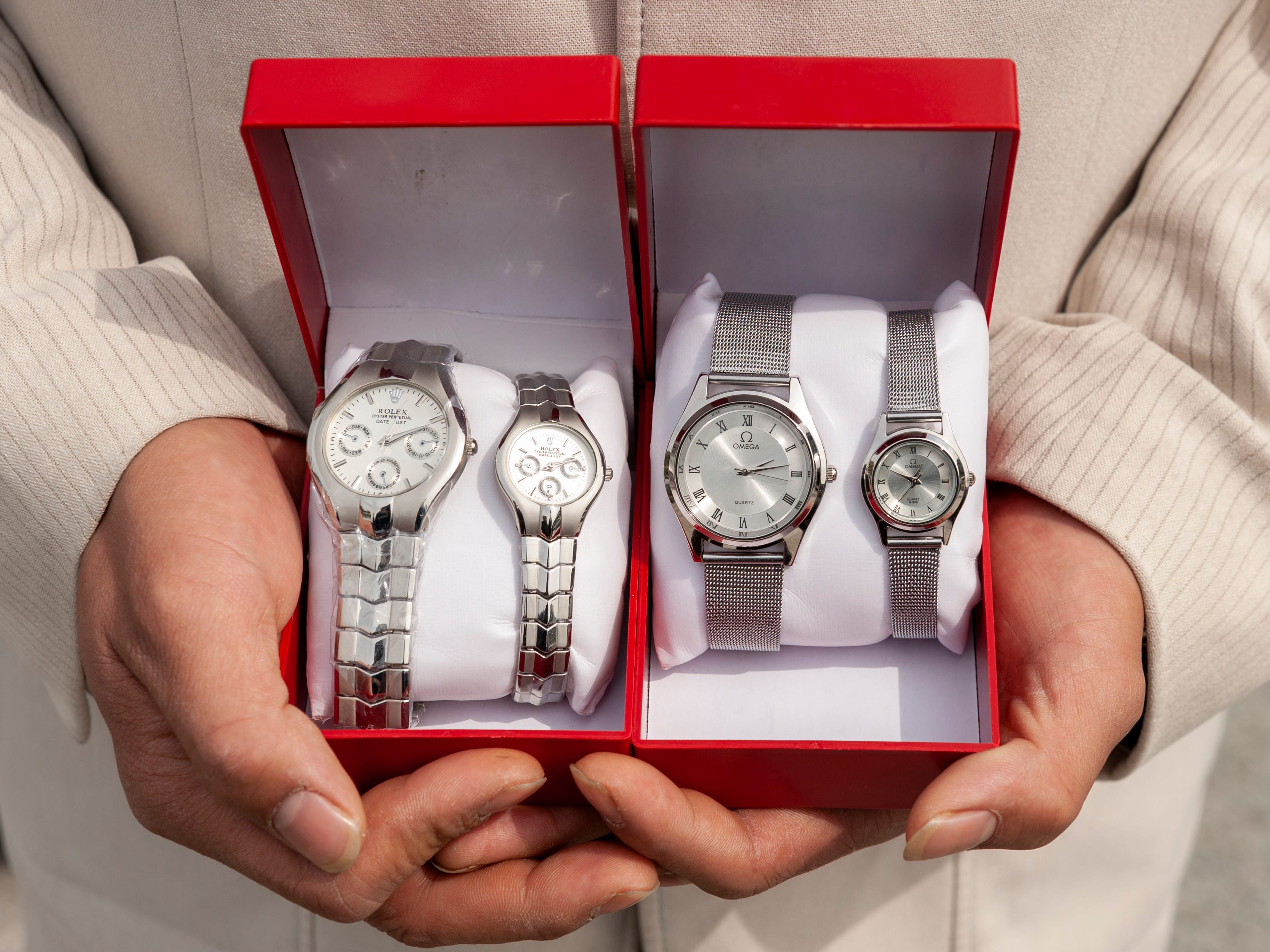 Hands holding counterfeit watches