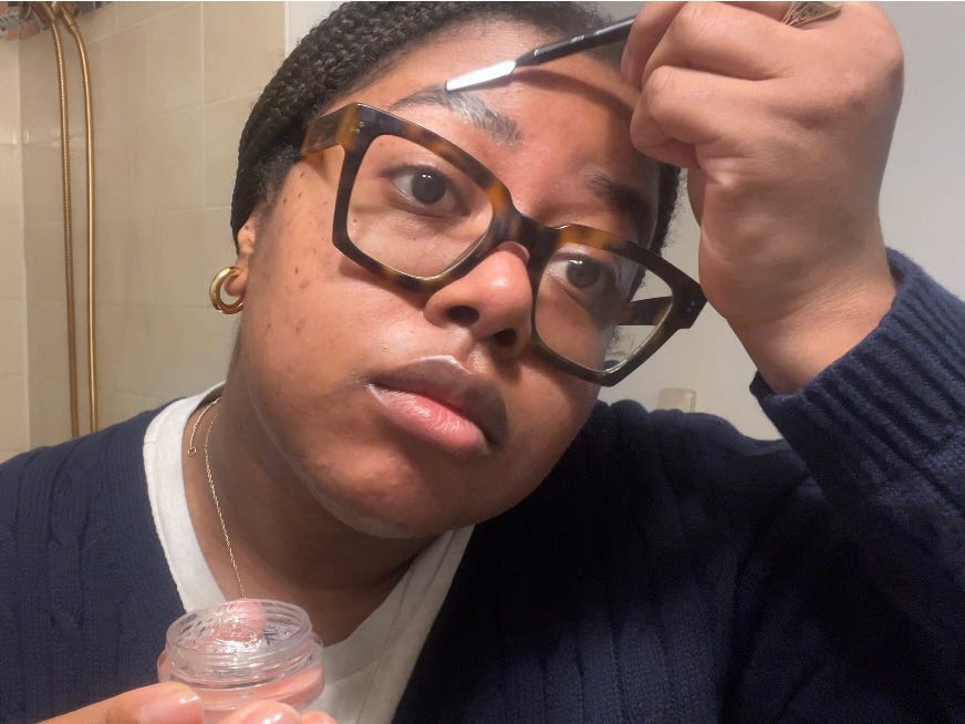 Lacey applies gel to her eyebrows.