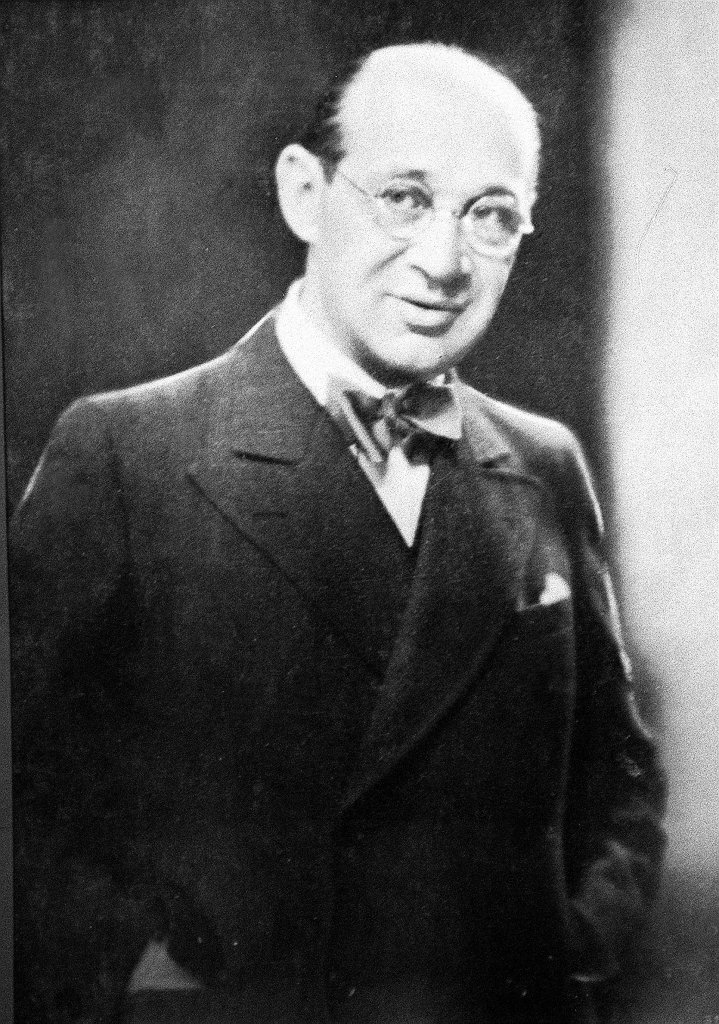 A black and white photo of a man in glasses