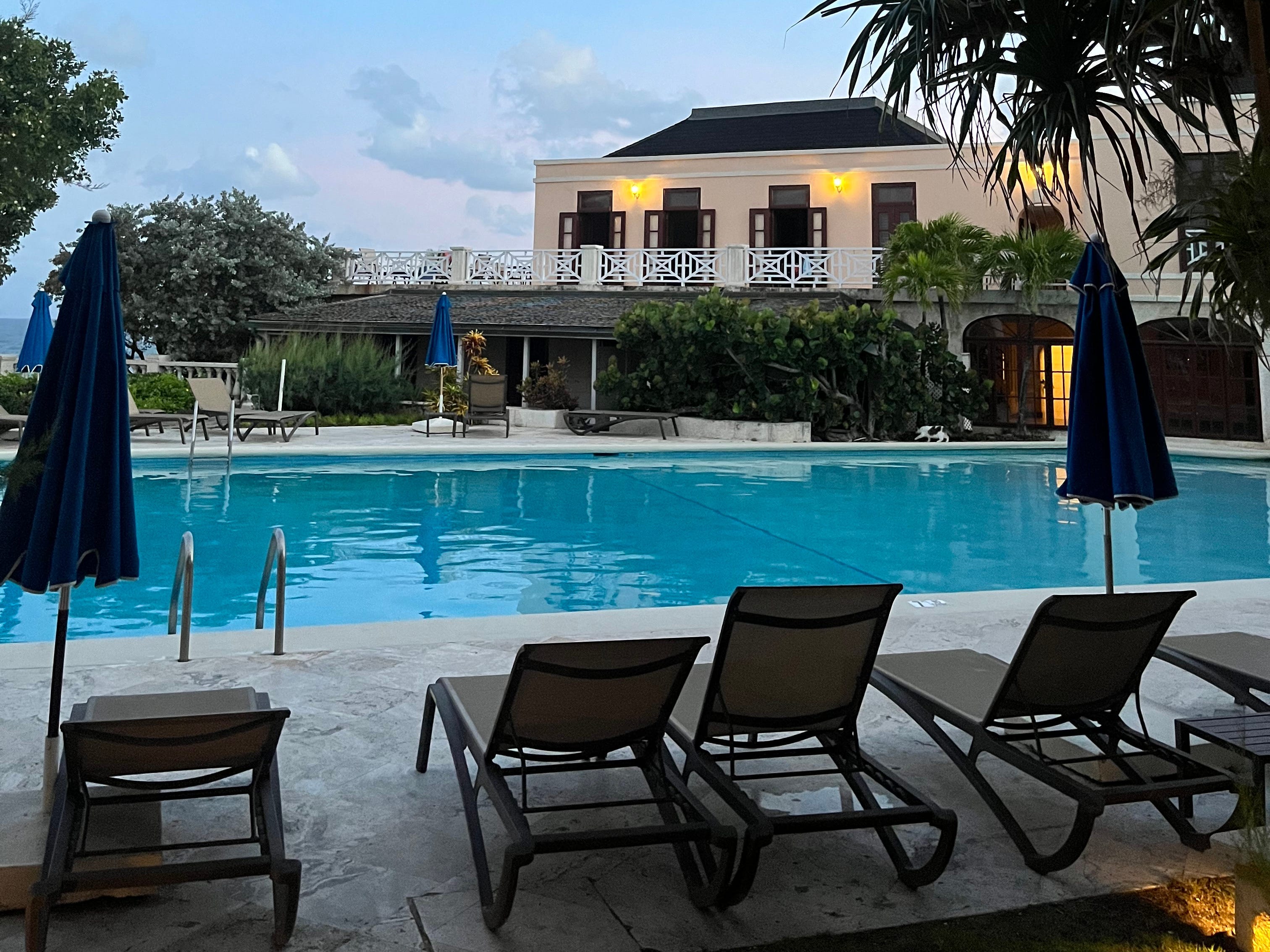 A hotel pool surrounded by lounge chairs.